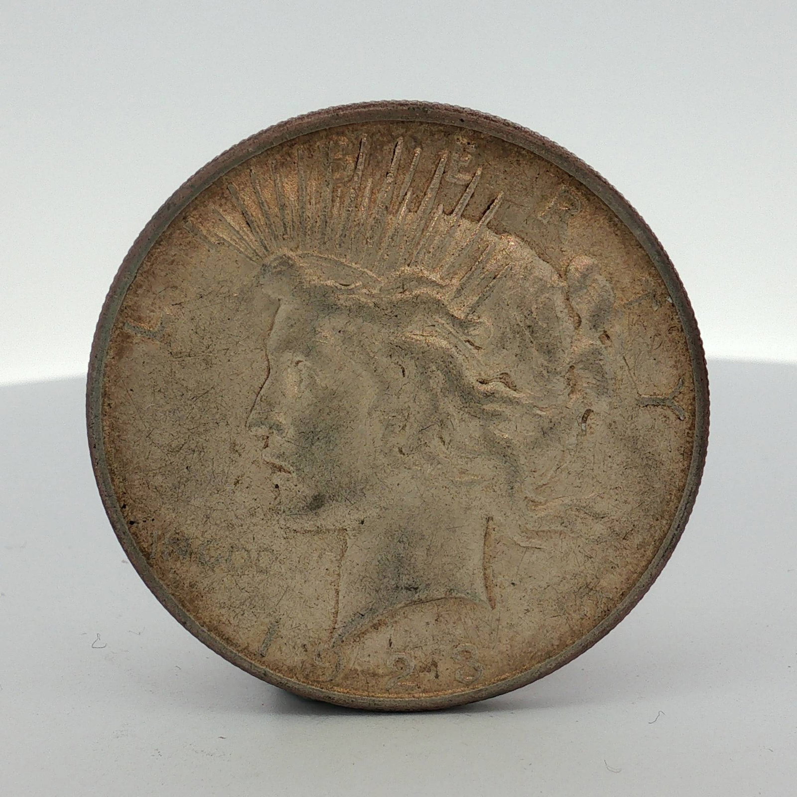1923-S US Peace Silver Dollar: This US 1923 Peace silver dollar is struck in a composition of 90 percent silver and 10 percent copper. The obverse features the Peace dollar design and the date 1923. The reverse includes the