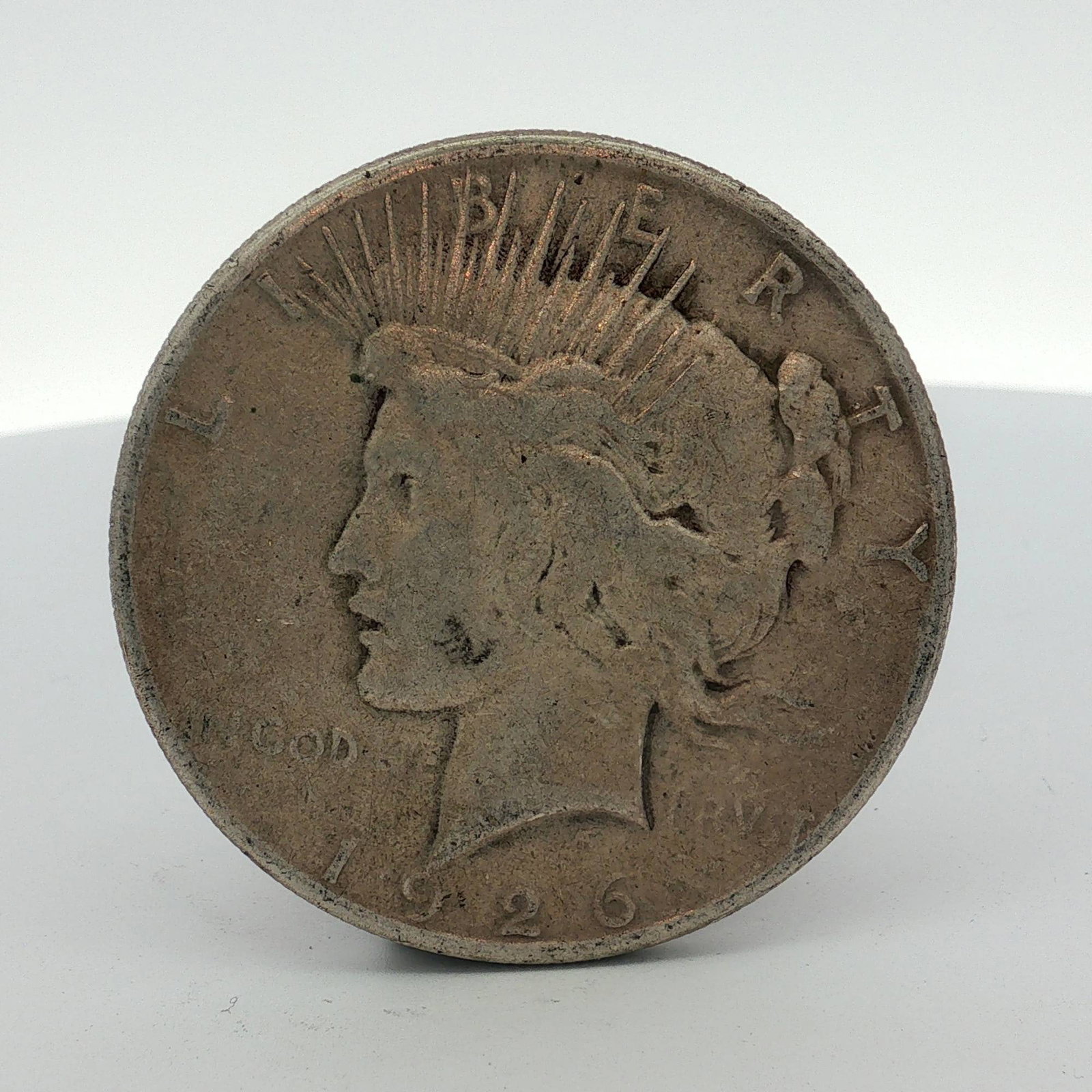 1926-S US Peace Silver Dollar: This US Peace silver dollar, minted in 1926 at the San Francisco Mint, is composed of 90% silver and 10% copper. The obverse features the Peace dollar design with a left-facing profile of Liberty wear