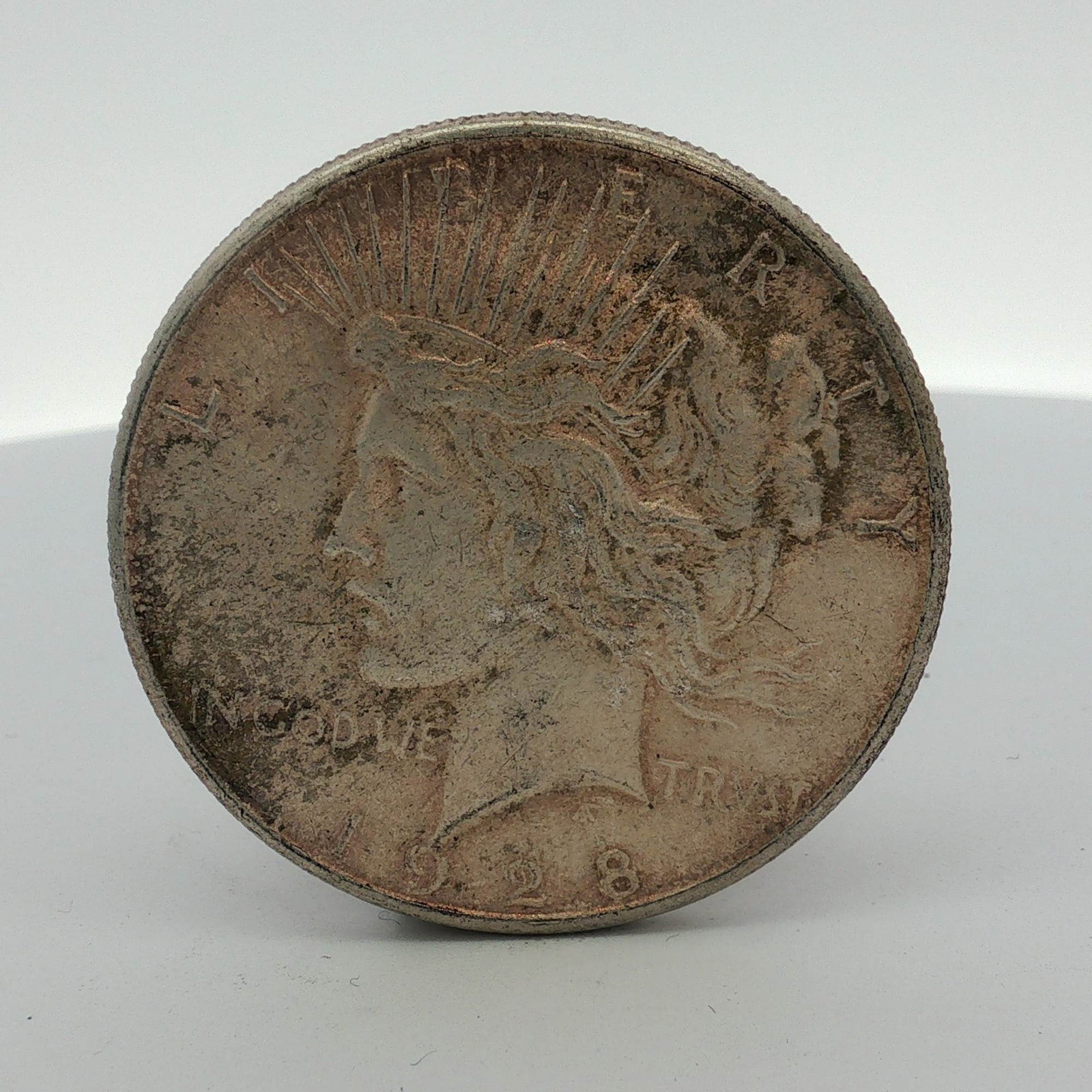 US 1928-S Peace Silver Dollar: US 1928-S Peace silver dollar. This coin is composed of 90% silver and 10% copper. It features the standard Peace dollar design by Anthony de Francisci. The obverse displays the Liberty head with a