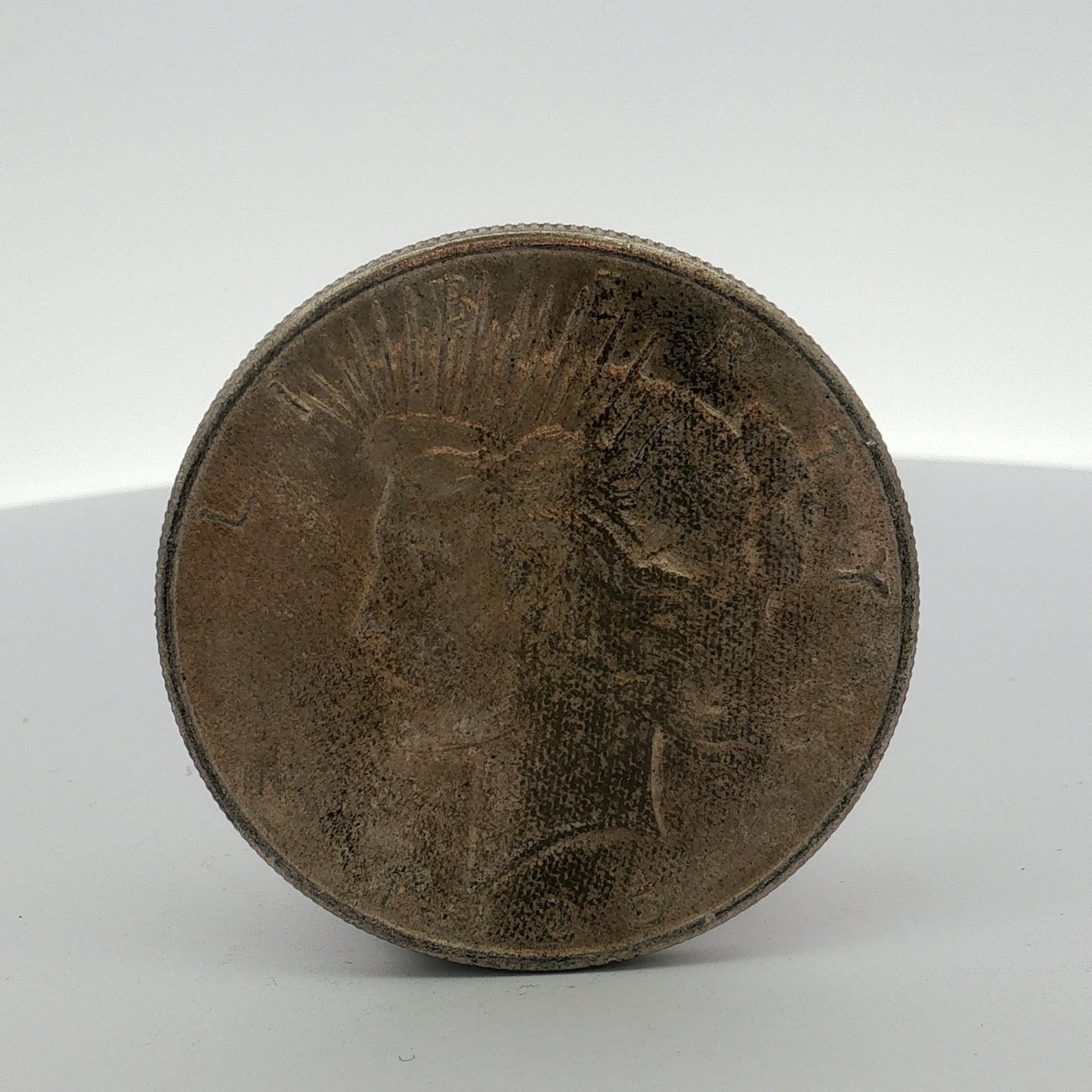 US Peace Silver Dollar: This US Peace silver dollar is composed of 90% silver and 10% copper. The coin features the standard Peace dollar obverse with a profile of Lady Liberty and the inscriptions LIBERTY and IN GOD WE TRVS