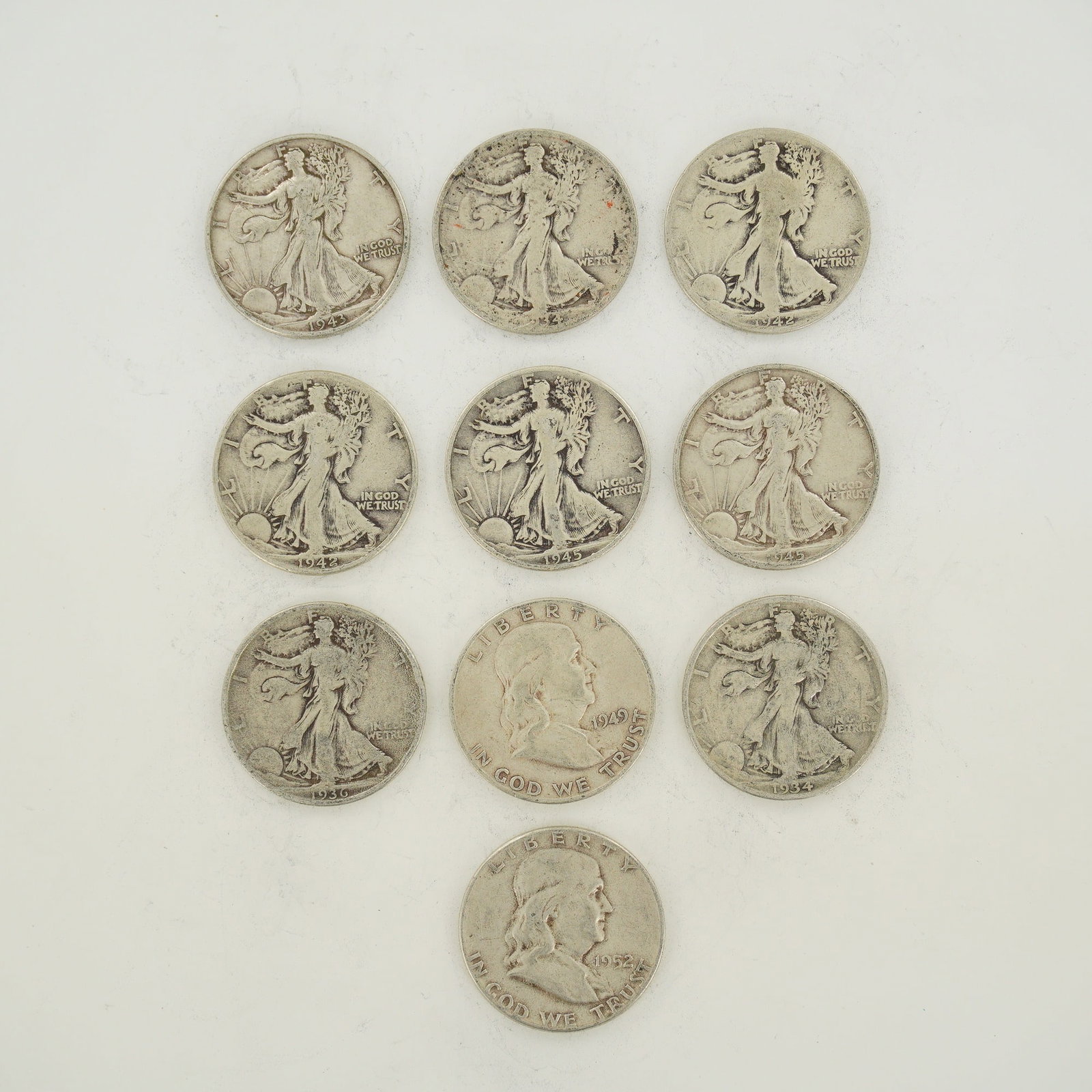 A Collection of 10 US Silver Walking Liberty and Franklin Half Dollars: A collection of ten US silver half-dollars consisting of eight Walking Liberty half-dollars (KM# 142) and two Franklin half-dollars (KM# 199). The Walking Liberty specimens include the following dates