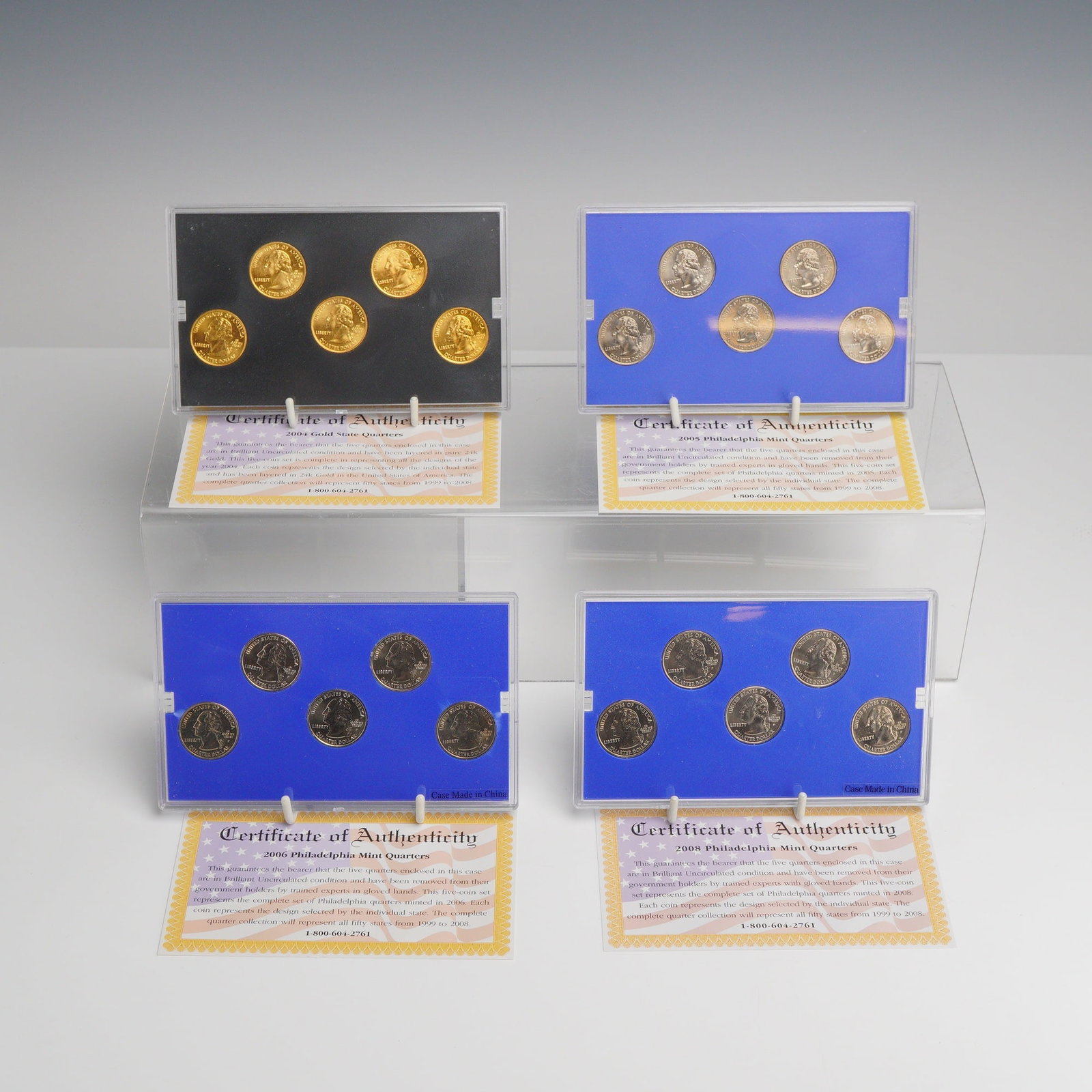 4pc US State Quarter Sets, 2004-2008: A collection of 4 US State Quarter sets comprising five-coin sets from the years 2004, 2005, 2006, and 2008. The 2004 set features quarters layered in 24 karat gold. The 2005, 2006, and 2008 sets are 