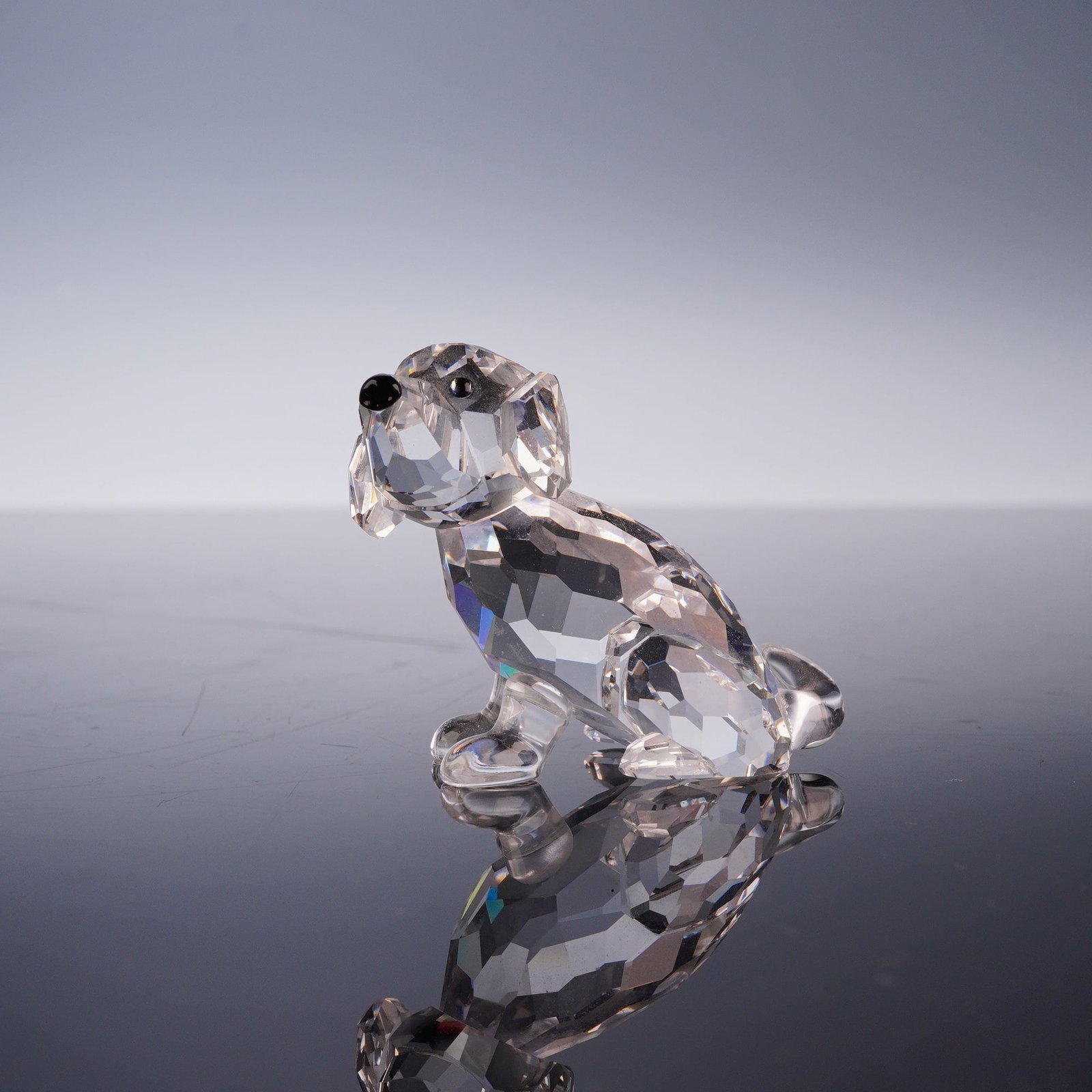 Swarovski Crystal Figurine, St. Bernard Puppy with Original Box: This Swarovski crystal figurine depicts a sitting St. Bernard puppy, designed by Edith Mair as part of the Pets Corner collection. The piece is constructed from faceted clear lead crystal with smooth,