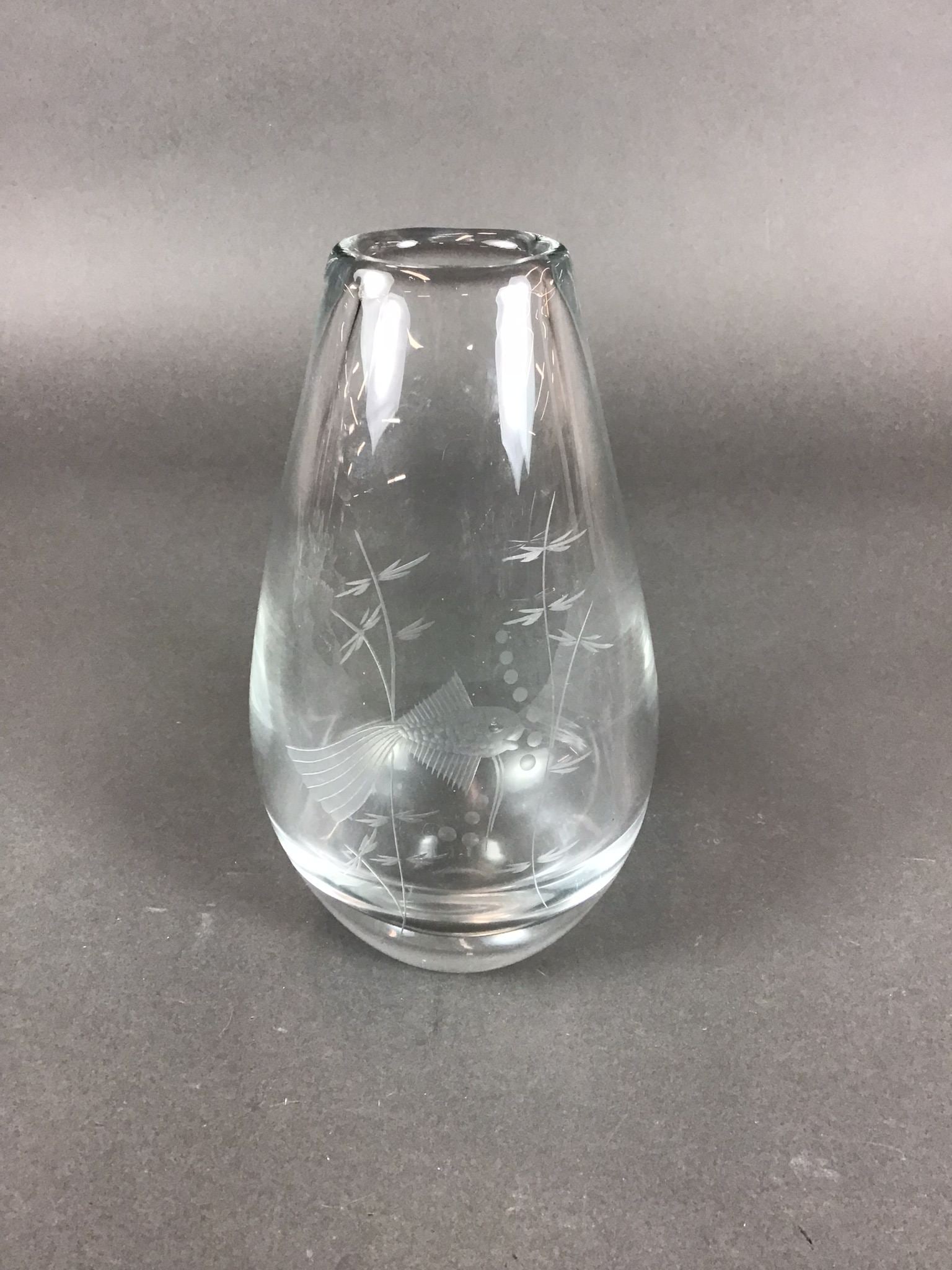 Kosta Boda by Vicke Lindstrand Etched Glass Teardrop Vase Fish and Seaweed Design: A Kosta Boda etched glass teardrop vase in the Fish and Seaweed design by Vicke Lindstrand. This Swedish art glass vessel is composed of clear, thick-walled glass in a tapered ovoid form. The exterior