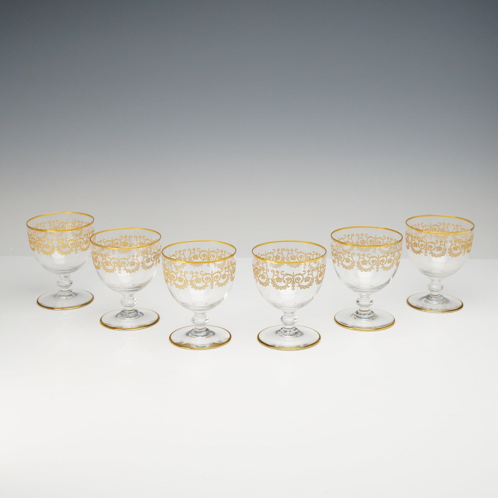 6pc Baccarat Gilded Crystal Cordial Glasses, Flora: This set of six Baccarat gilded crystal cordial glasses is executed in the Flora pattern. Each piece is manufactured from clear lead crystal and features hand-blown construction. The decorative