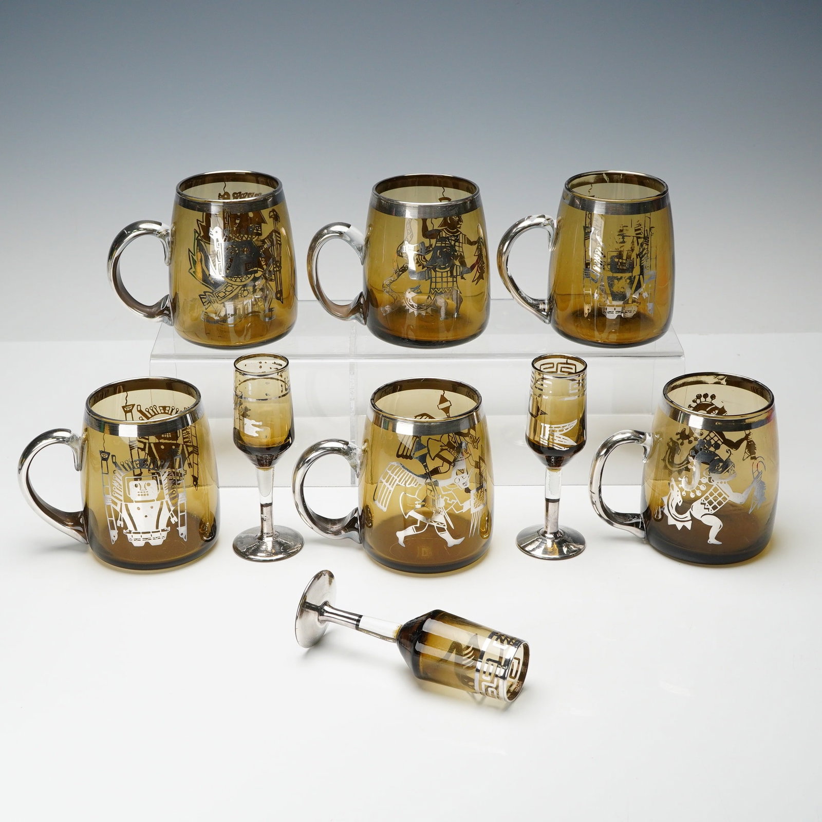 9pc Silver Overlay Figural Motif Amber Glass Mugs and Cordials Set: Beverage set consisting of six handled amber glass mugs and three matching cordials, each decorated with silver overlay and stylized Mesoamerican figural scenes. The mugs feature wide rounded forms