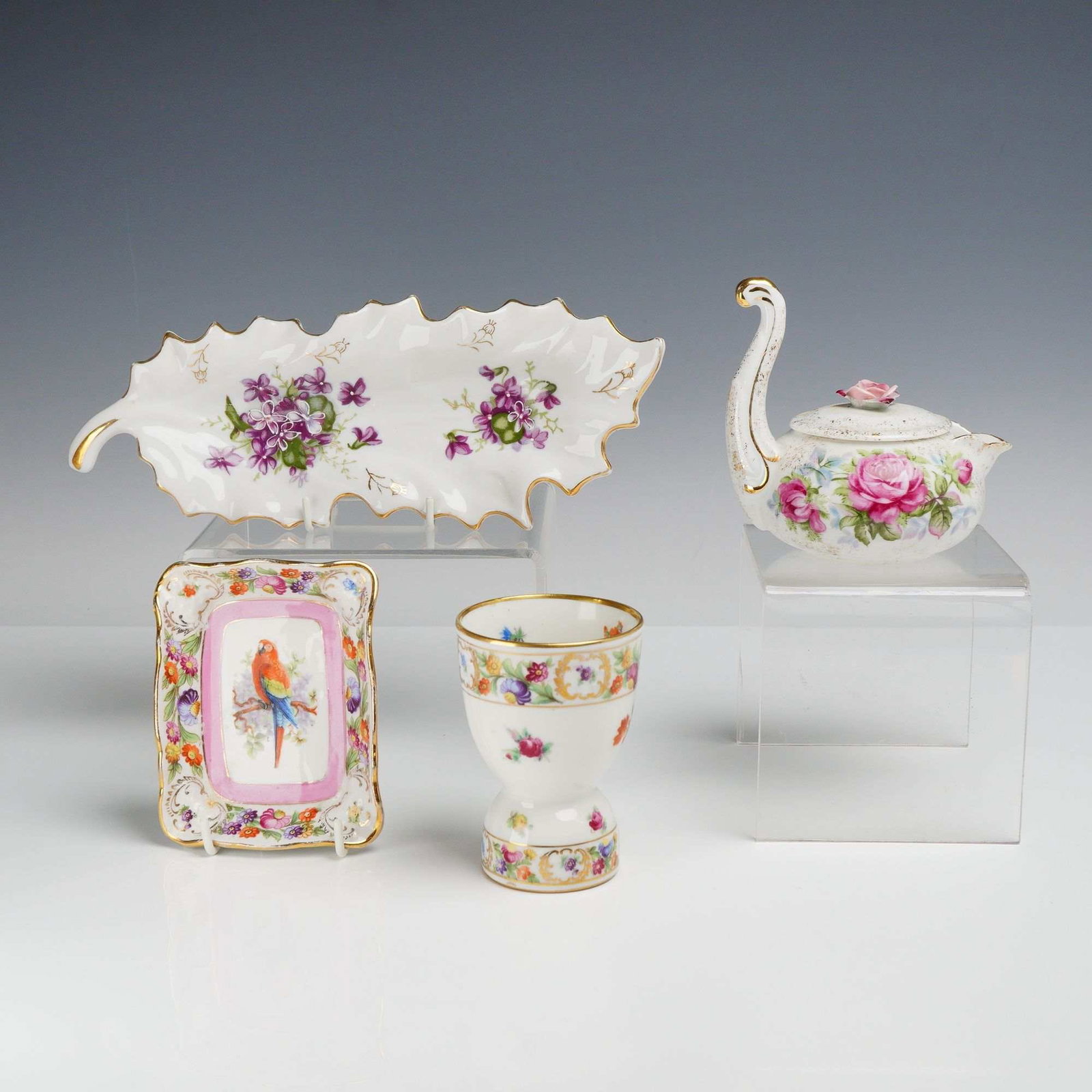 4pc Porcelain Items including Lefton and Shumann Empress: This lot of 4 porcelain items features a variety of hand-painted decorative cabinet pieces. Included is one Lefton hand painted floral teapot with lid, designed with a handle shaped like a swan neck a