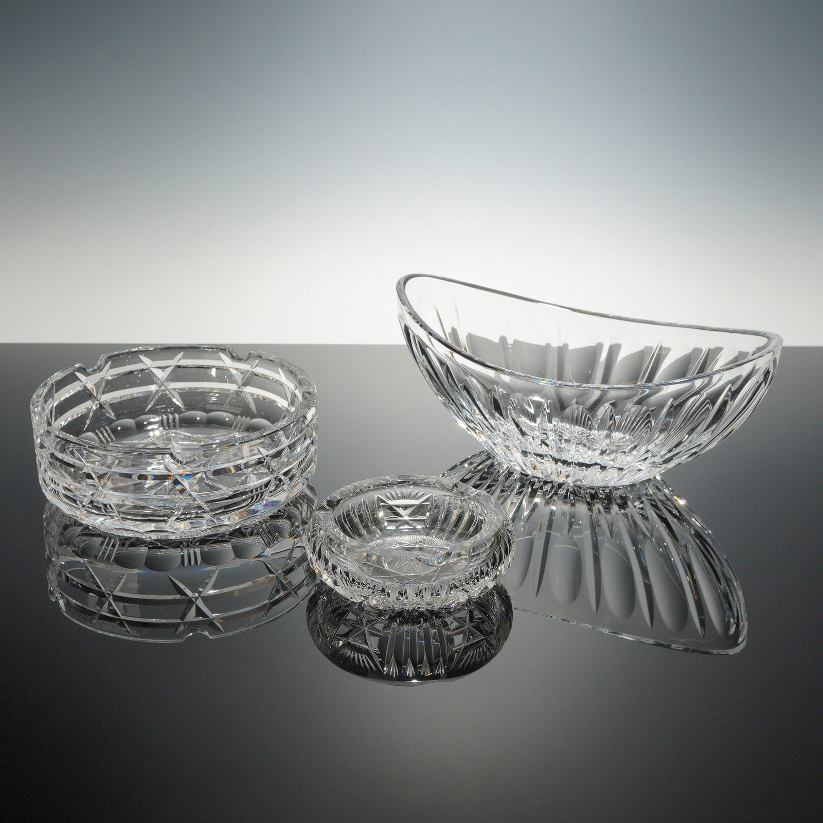 Three Pieces of Cut Lead Crystal Tableware in the Style of Godinger Dublin: This collection of 3 items glass features high-quality lead crystal characterized by deep, precision-cut geometric patterns and exceptional clarity. The set includes a large navette-shaped