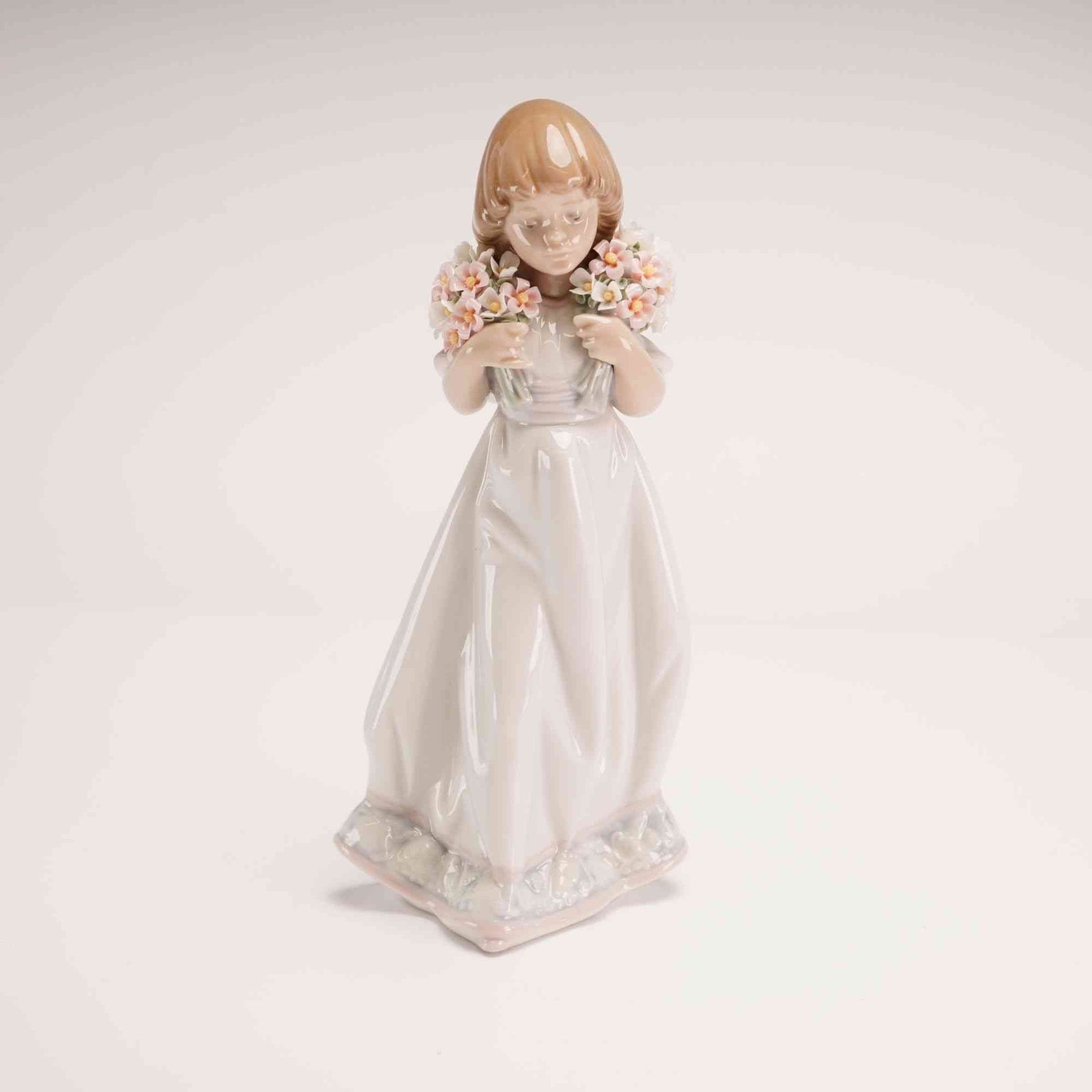 Lladro Glazed Porcelain Figurine Spring Bouquets 01007603 with Box: This Lladro glazed porcelain figurine was issued in 1987 specifically for members of the Lladro Collectors Society. The piece depicts a young girl with light brown shoulder-length hair, dressed in a l