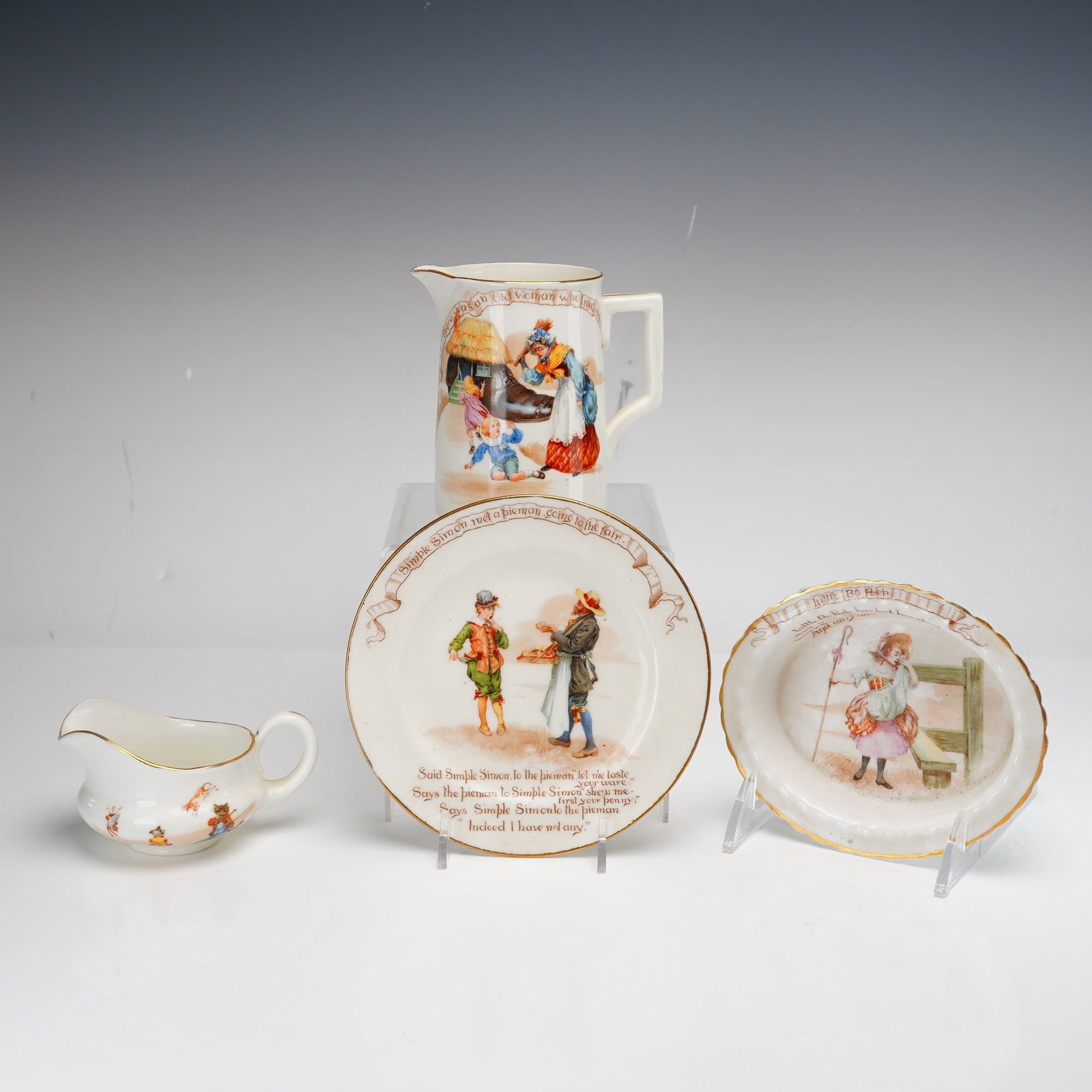 4pc Set of Royal Doulton Nursery Rhyme Ceramics: This 4pc set of Royal Doulton dishes is from the Nursery Rhymes series, featuring transfer-printed illustrations after designs by William Savage Cooper. The collection is crafted from fine earthenware