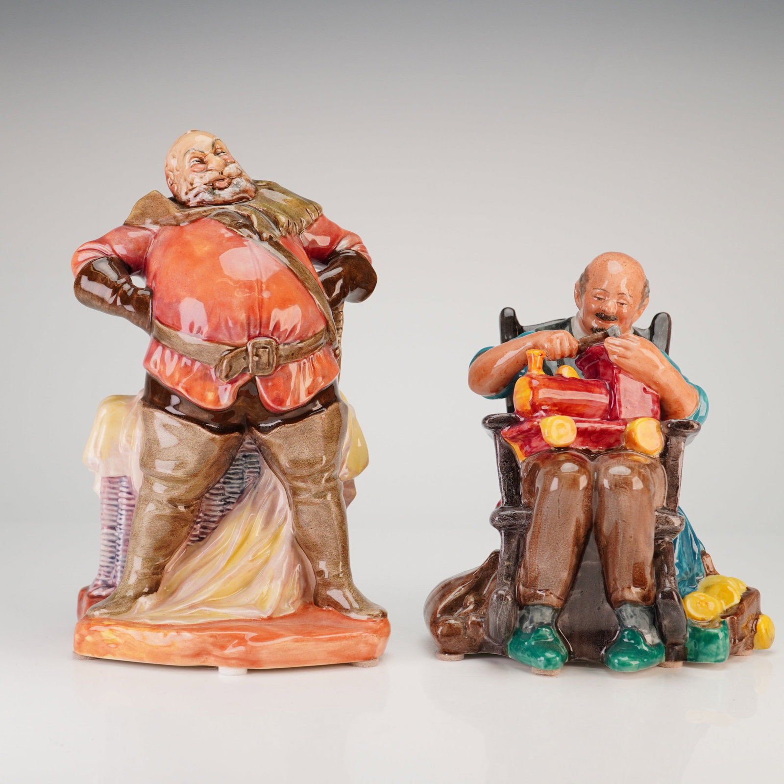 2pc Royal Doulton Figurines, Falstaff HN 2054 & The Toymaker HN 2250: A lot of 2 Royal Doulton porcelain figurines featuring the characters Falstaff and The Toymaker. Both pieces are crafted from polychrome glazed porcelain with a high-gloss finish. The first figurine, 