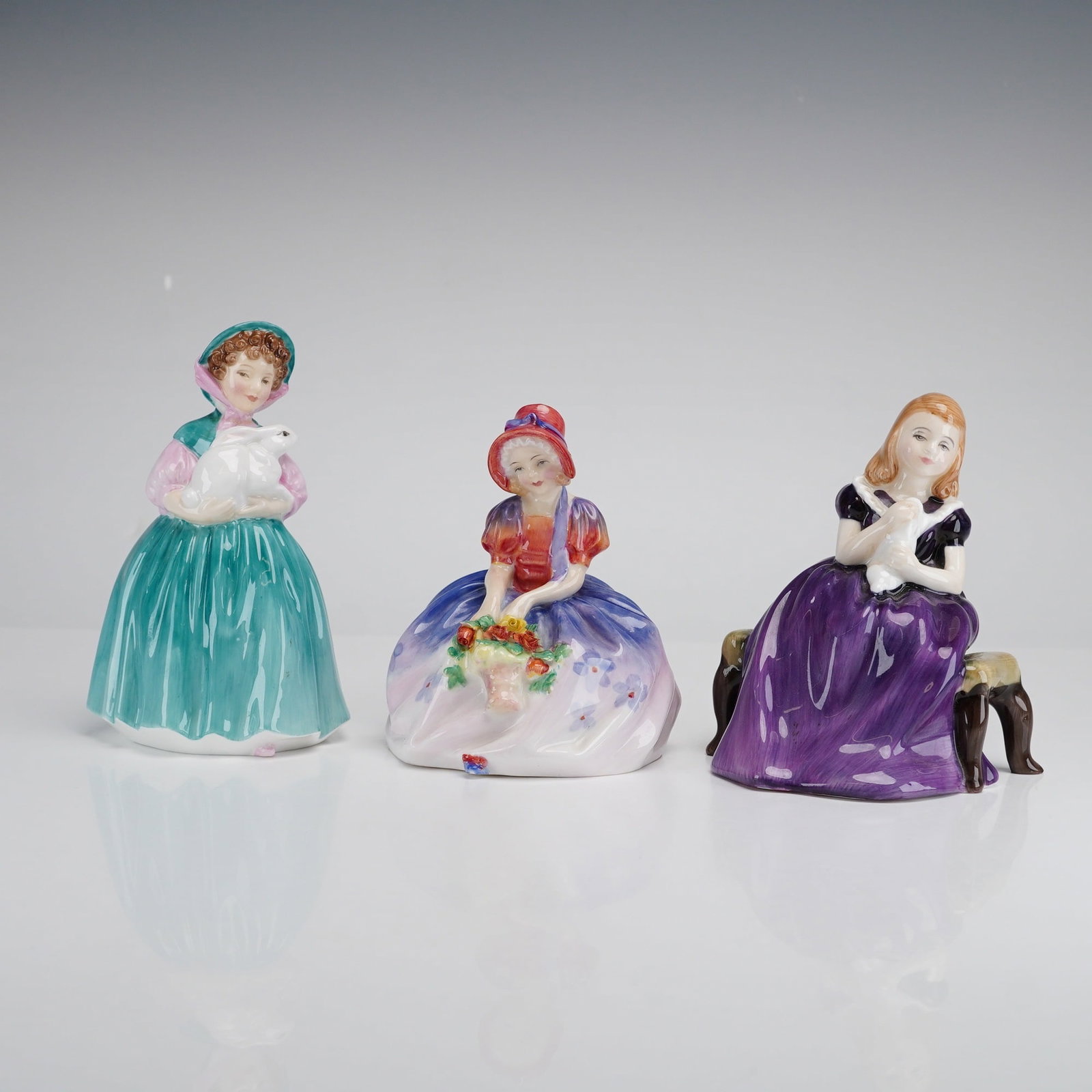 Royal Doulton Figurines, Bunny HN2214, Monica HN1467, and Affection HN2236: This collection consists of three vintage Royal Doulton glazed fine bone china figurines. The set includes Bunny (HN 2214, copyright 1957), featuring a young girl in a teal-green skirt and bonnet crad