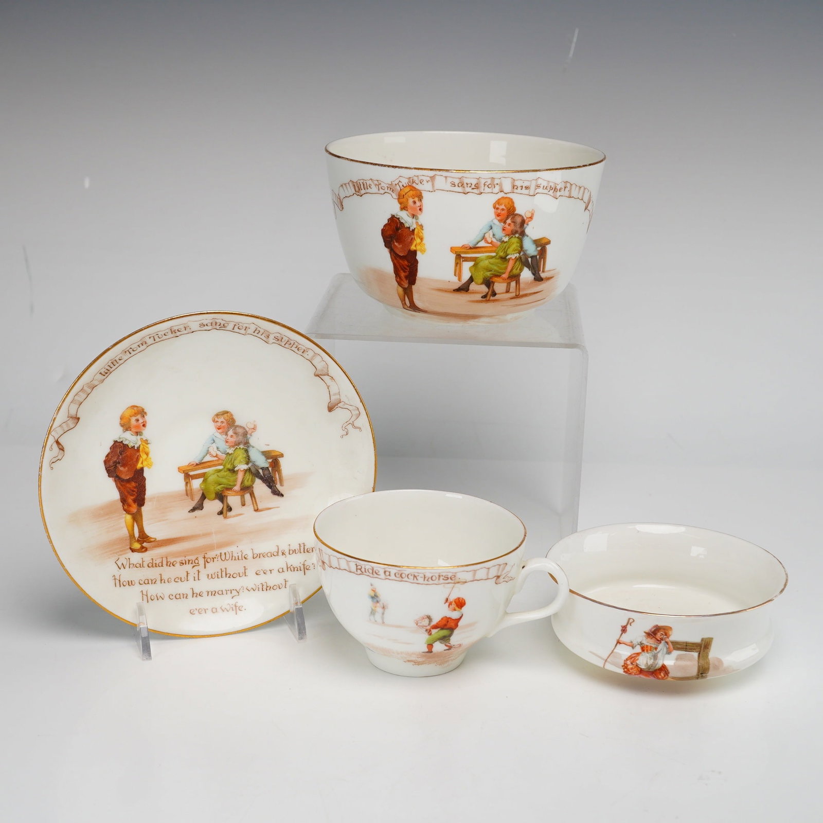 A 4-Piece Royal Doulton Nursery Rhymes Ceramic Set of Dishes: This is a 4-piece set of Royal Doulton ceramic dishes from the Nursery Rhymes series, featuring illustrations designed by William Savage Cooper. The set includes two small bowls, a saucer, and a teacu