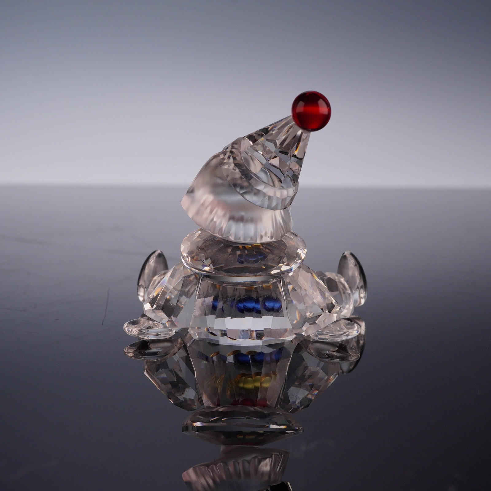 Swarovski Crystal Figurine, Puppet with Original Box: A Swarovski lead crystal figurine identified as the Sitting Clown or Puppet Clown from the When We Were Young collection, designed by Gabriele Stamey. The figure is depicted in a seated pose with
