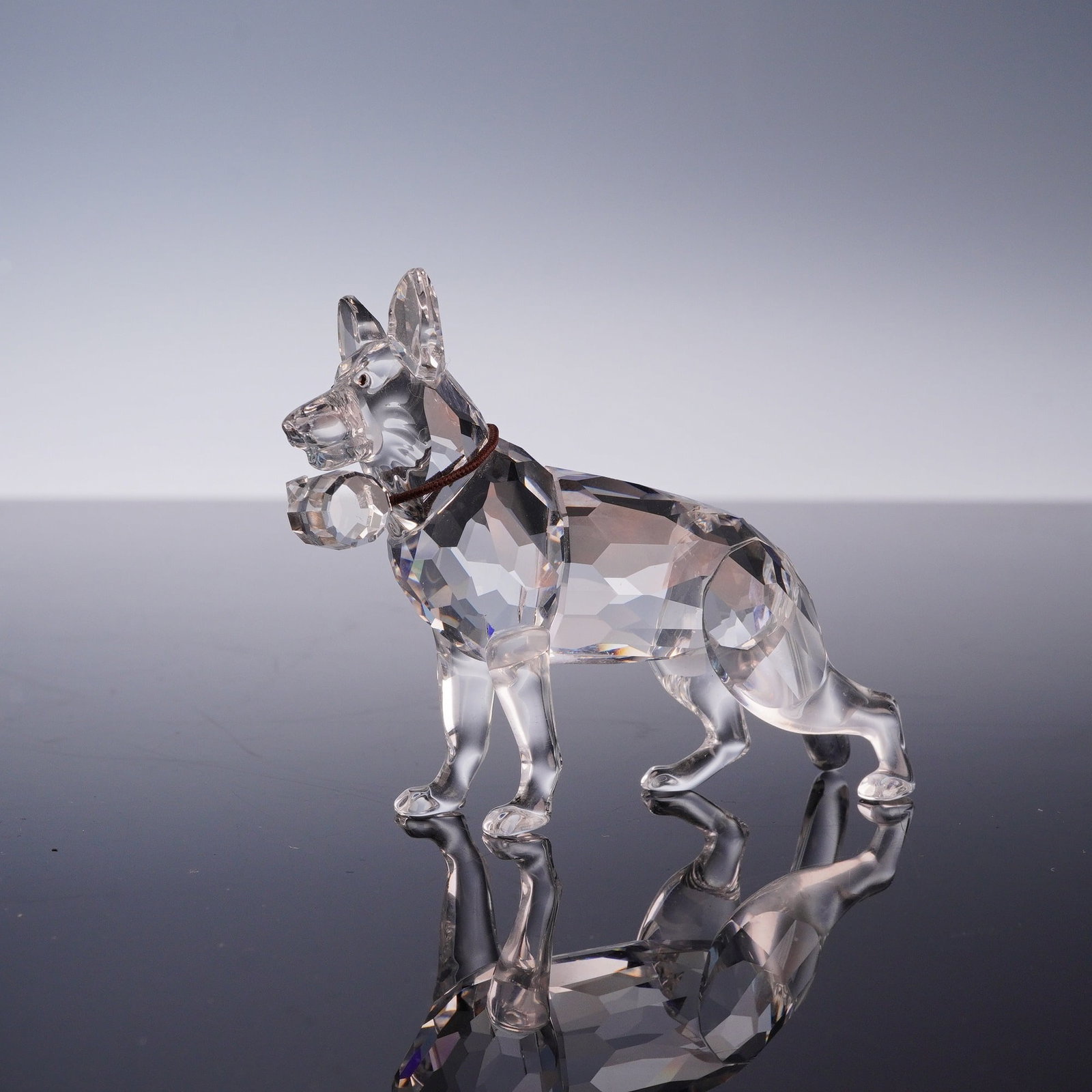Swarovski Crystal Figurine, German Shepherd: This Swarovski lead crystal figurine depicts a German Shepherd dog, from the Best Friends or Pets Corner collection. The piece is constructed with a faceted crystal head and body, complemented by