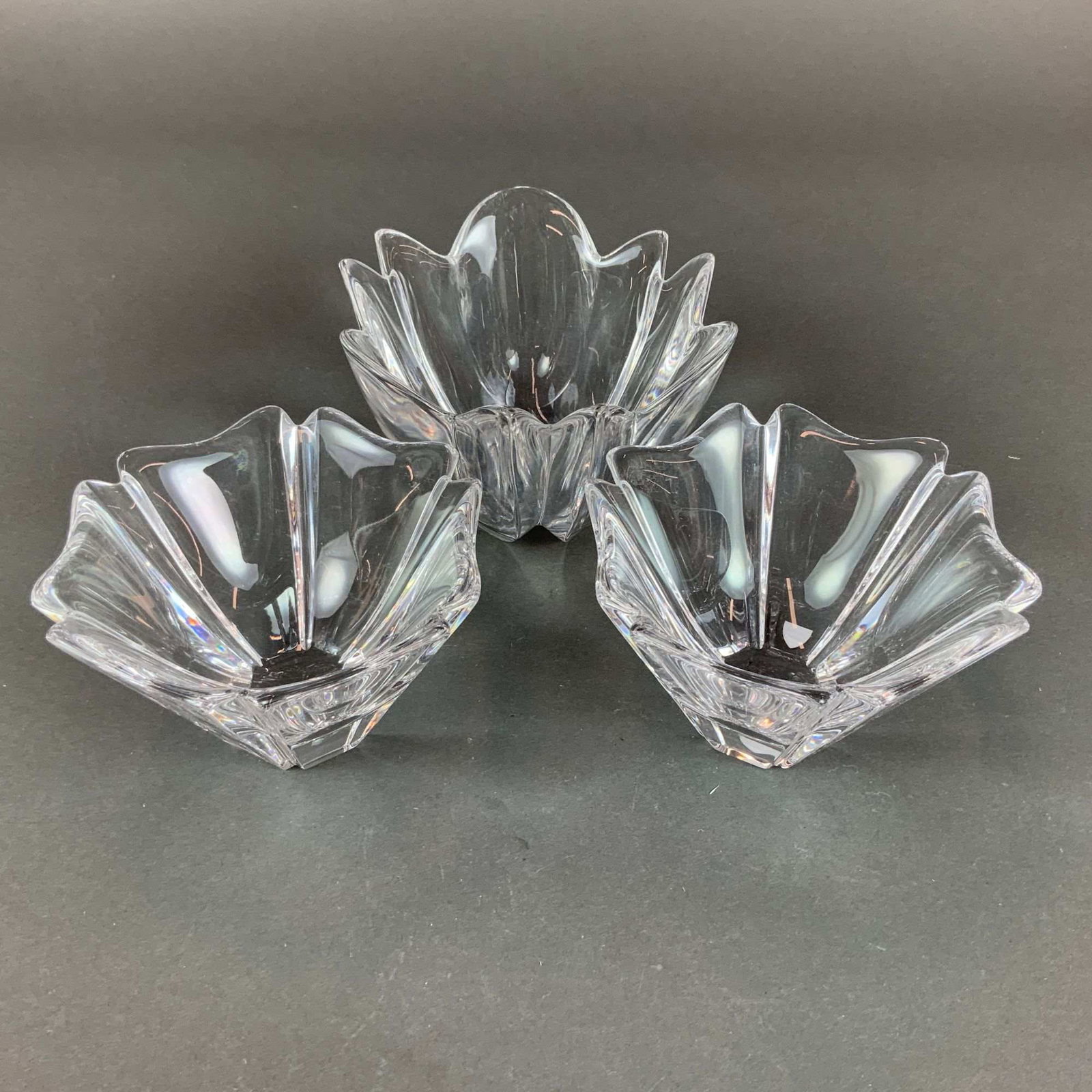 3pc Orrefors Crystal Lily Bowls: A trio of Orrefors crystal lily bowls manufactured in Sweden. This set consists of one larger bowl and two smaller matching bowls. Each piece is crafted from heavy, high-quality clear crystal and feat
