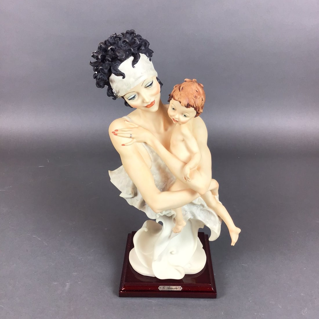 Giuseppe Armani Florence Porcelain Sculpture, Mother and Child: This sculpture is an authentic production by Giuseppe Armani for the Florence Sculpture d'Arte studio. The piece is an Art Deco-inspired composition depicting a woman in an elaborate 1920s-style headp
