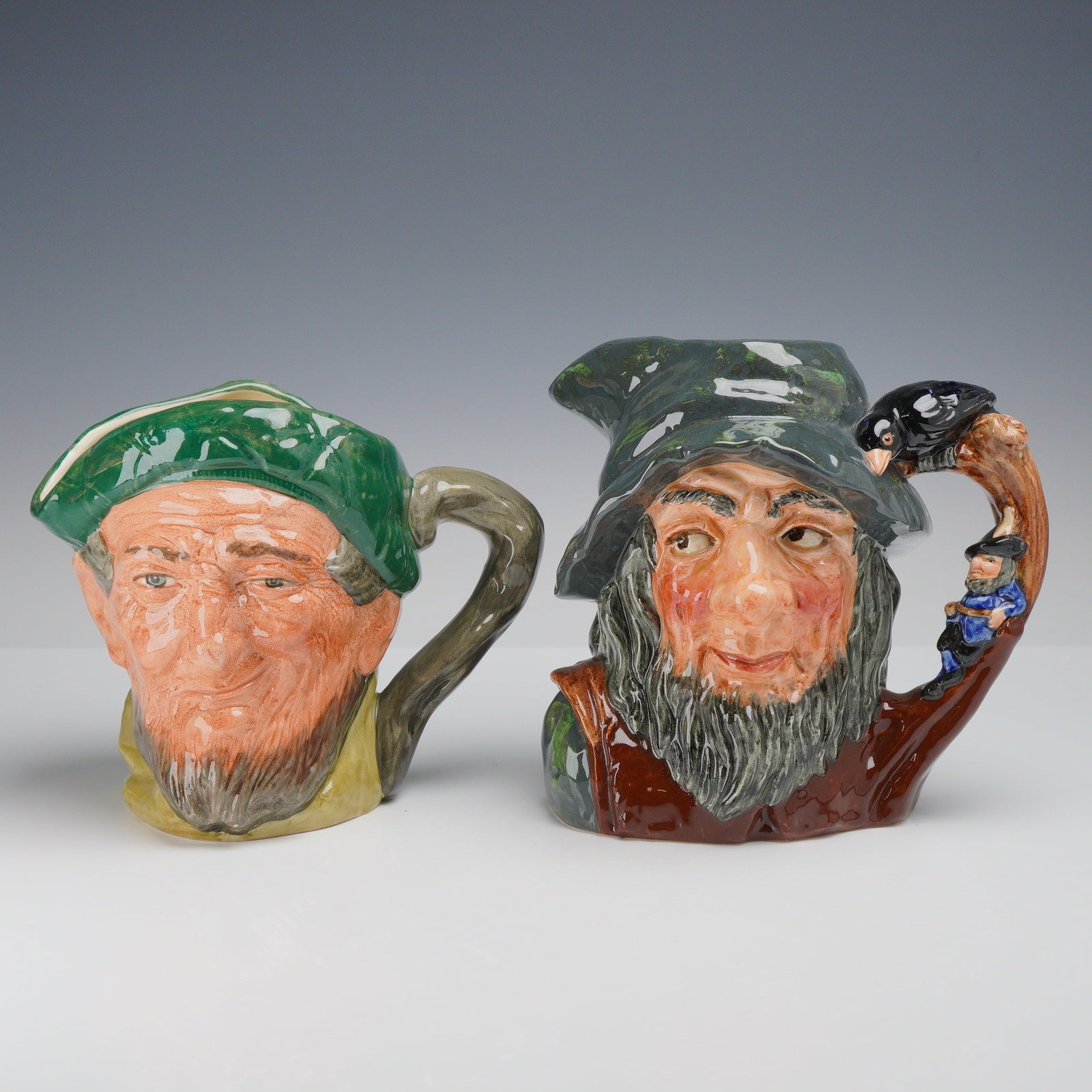 2pc Royal Doulton Character Jugs, Auld Mac D5823 and Rip Van Winkle D6438: This lot features two Royal Doulton character jugs: "Auld Mac" (D5823) and "Rip Van Winkle" (D6438). The first Auld Mac, depicts an elderly man with a brown beard in a green tam-o'-shanter. The second