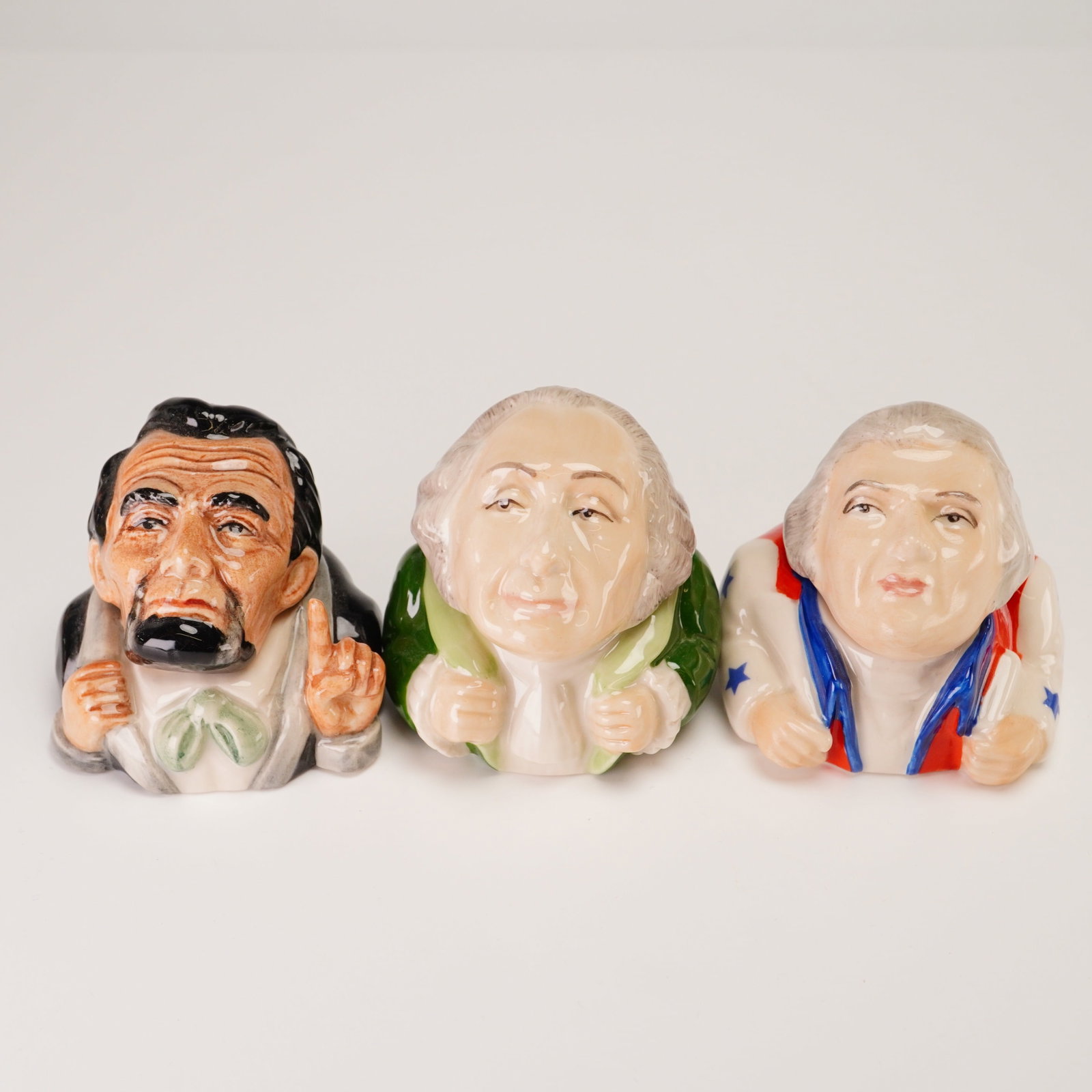 3pc Kevin Francis Face Pots, Lincoln, Washington, and Jefferson: This lot comprises three hand-painted glazed ceramic lidded containers, identified as Face Pots, produced by Kevin Francis in England. Each piece is modeled as a stylized bust of an American president