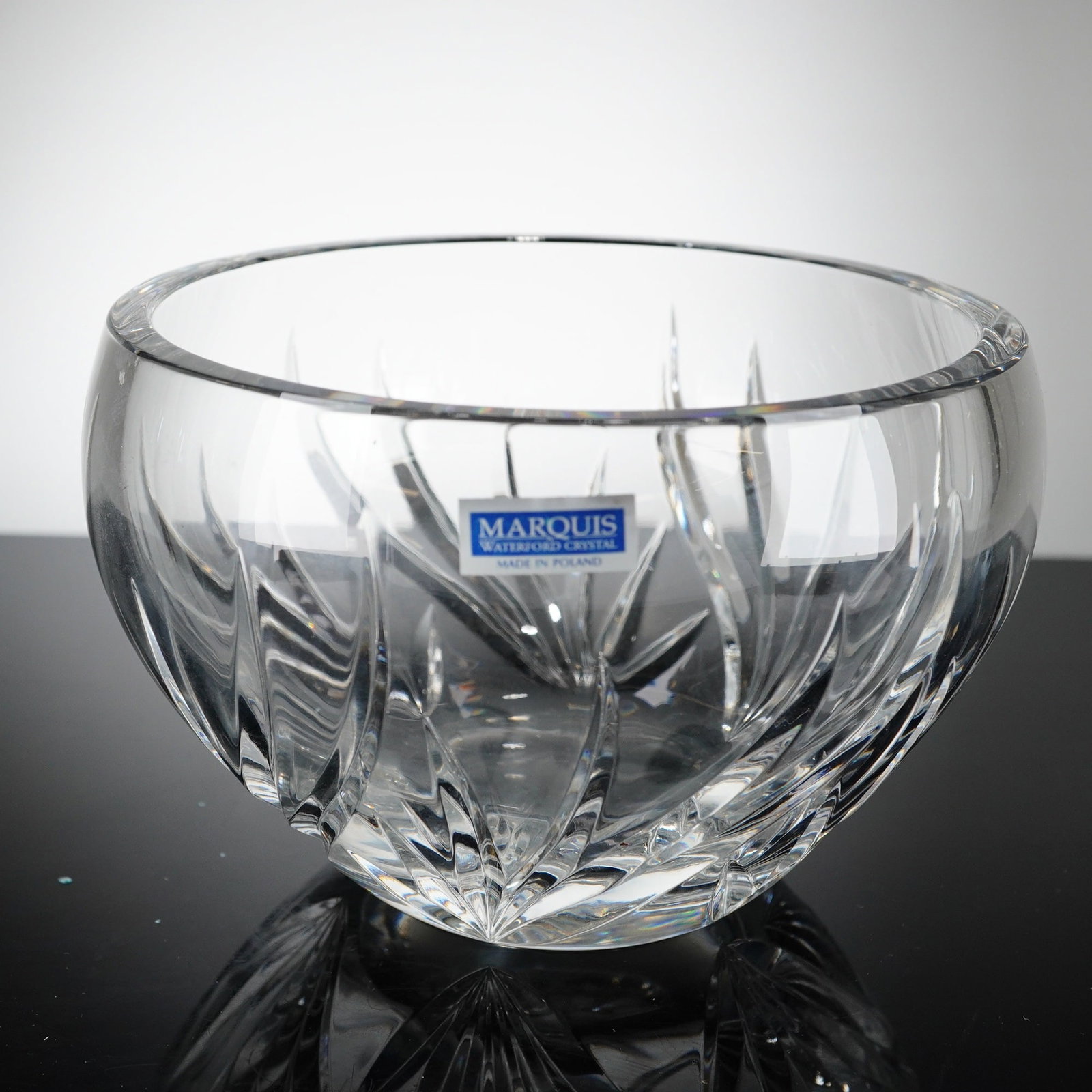 Marquis by Waterford Wyndmere Cut Crystal Bowl: A Marquis by Waterford crystal bowl in the Wyndmere pattern, manufactured in Poland. The clear crystalline vessel is designed in a rounded rose-bowl form, decorated with deep, sweeping vertical wedge