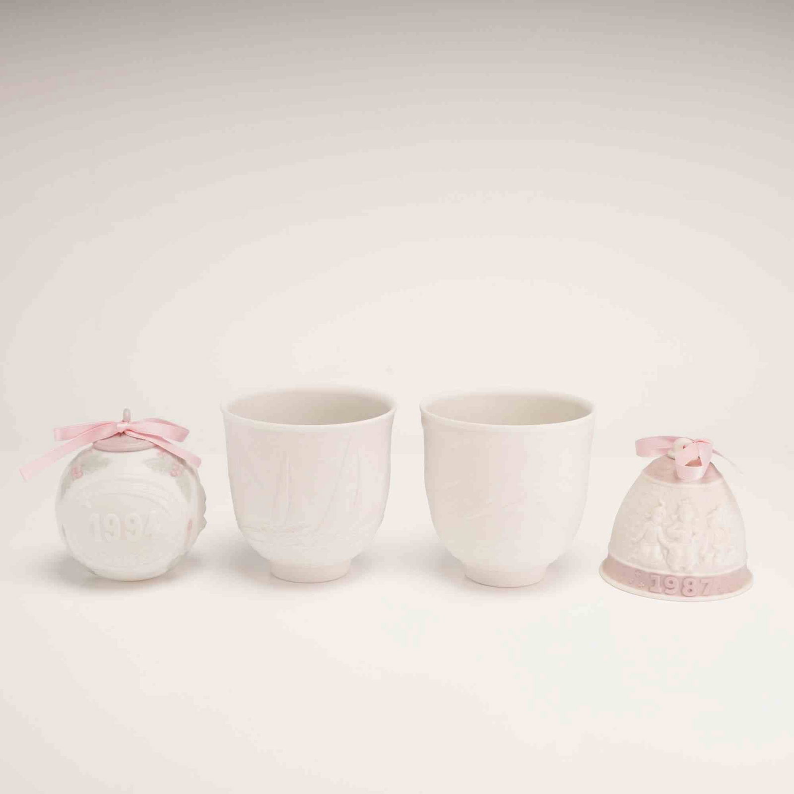 4pc Lladro Porcelain Ornaments and Collectors Society Candle Holders: This lot features a collection of four matte white porcelain pieces by Lladro, manufactured in Spain. The grouping consists of commemorative holiday items and exclusive releases for the Lladro Collect