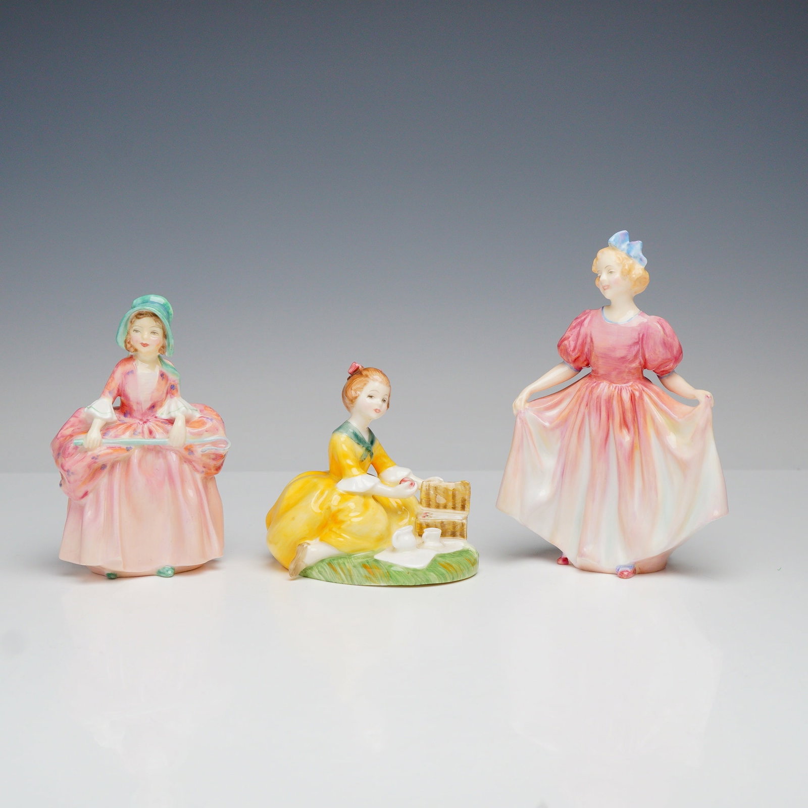3pc Royal Doulton Porcelain Figurines Bo-Peep Picnic and Sweeting: This lot consists of three Royal Doulton porcelain figurines. Each figure is made of glazed bone china and features hand-painted details. The first figurine is Bo-Peep, showing a girl in a pink floral