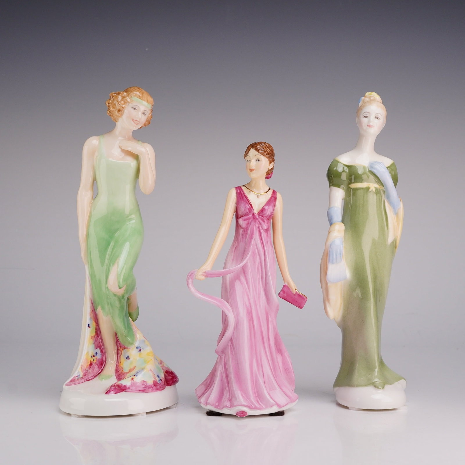 Three Royal Doulton Bone China Figurines- Monte Carlo HN2332, Julia 5664, and Lorna 2311: This lot features three Royal Doulton hand-decorated bone china figurines, each representing a distinct era of fashion. The first figurine, Monte Carlo (HN 2332), is part of the Sweet and Twenties Col