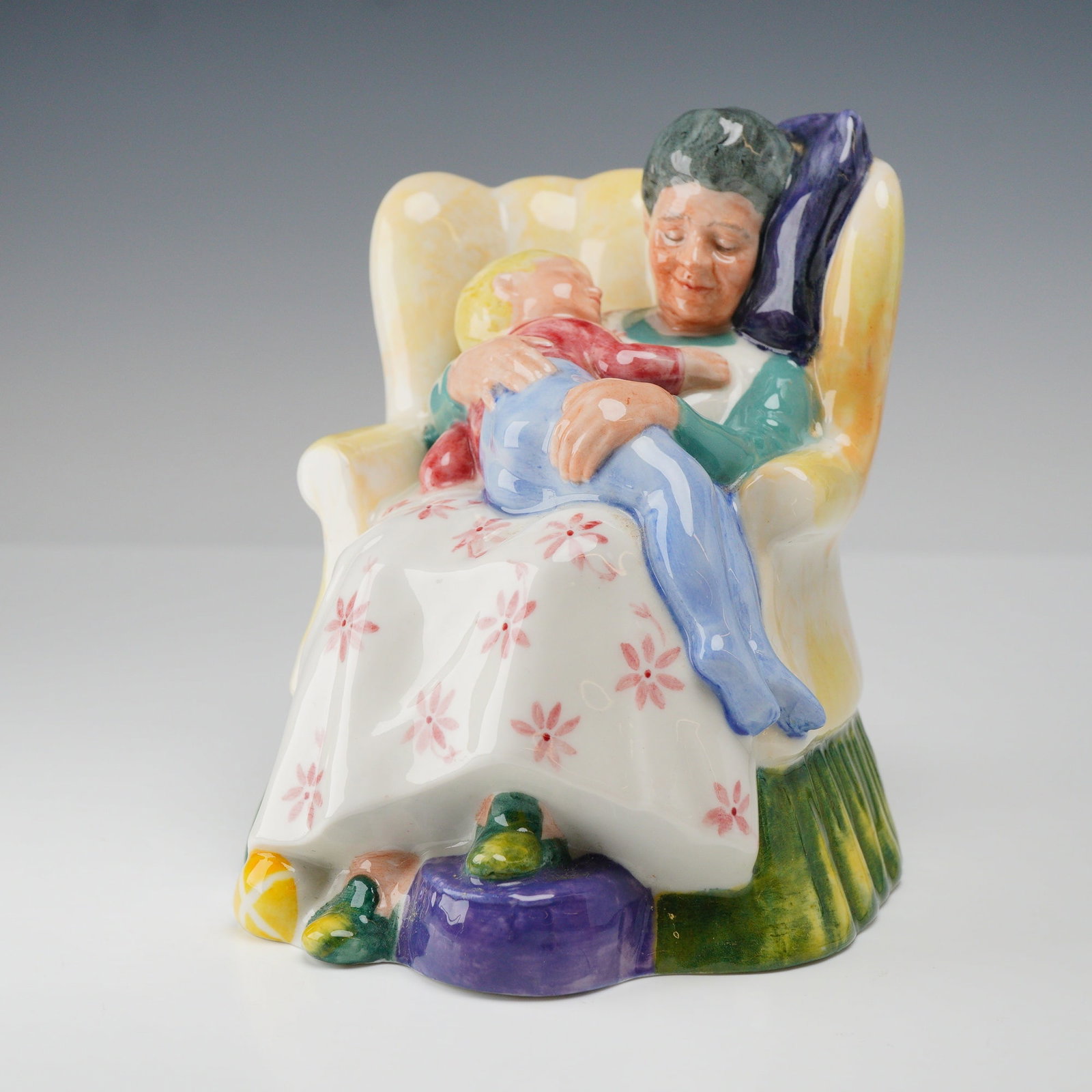 Royal Doulton Porcelain Figurine, Sweet Dreams HN2380: This glazed porcelain figurine, titled Sweet Dreams and numbered HN 2380, was manufactured by Royal Doulton in England. The piece depicts an elderly woman with gray hair seated in a yellow wingback ar