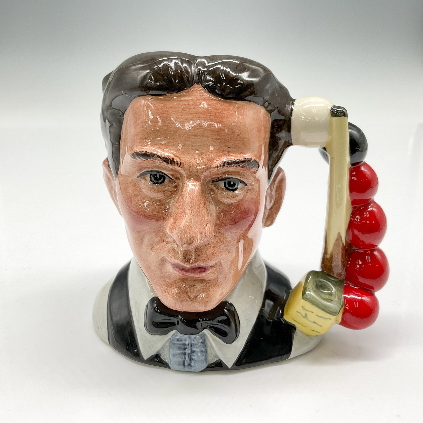 Snooker Player D6879 - Small - Royal Doulton Character Jug: Black hair; white shirt; black bow tie and vest. Royal Doulton backstamp. Artist: Stanley J. Taylor Dimensions: 4"H Date or Era: 1991 - 1995 Manufacturer or Brand: Royal Doulton Country of Origin: