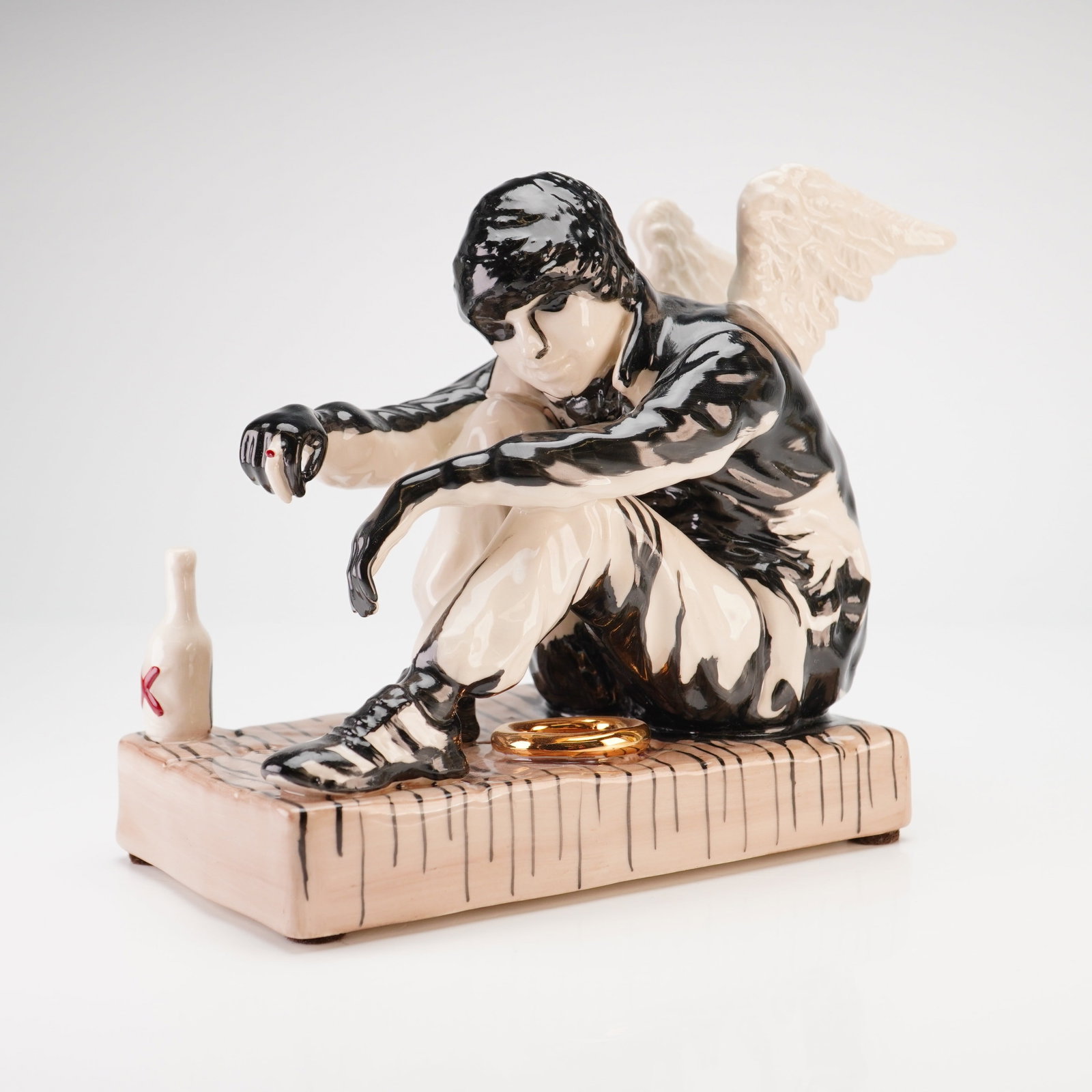 Kevin Francis Street Art Collection Banksy The Fallen Angel Sculpture inspired by Banksy Figurine: This is a contemporary glazed ceramic figurine from the Kevin Francis Street Art Collection, titled The Fallen Angel, inspired by Banksy. The piece depicts a winged male figure in a dejected, seated