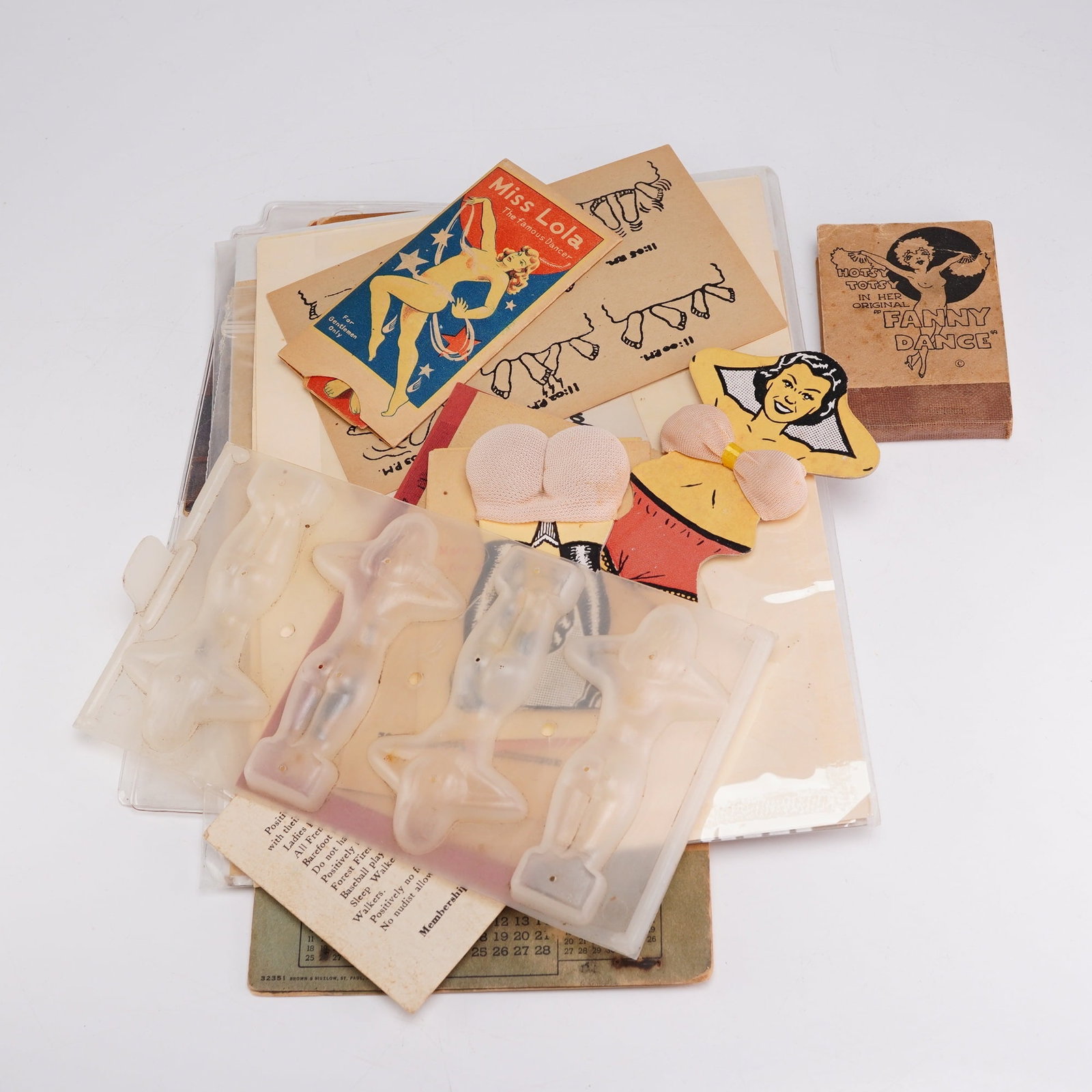 Collection of Mid-Century Pin-Up Ephemera & Risque Novelty Items: This collection consists of mid-century adult-oriented novelty ephemera and pin-up collectibles, primarily manufactured in the United States. The items are produced using offset lithography on cardsto