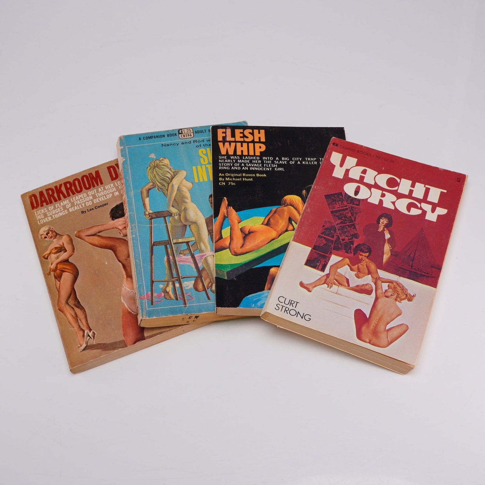 4pc Collection of Pulp Erotica Soft Cover Books: Four vintage adult fiction novels in mass-market paperback format, dating from the 1960s and early 1970s. The titles included are Darkroom Dyke by Les Cooper (Raven Books RB 737), Sucked Into Sin by N