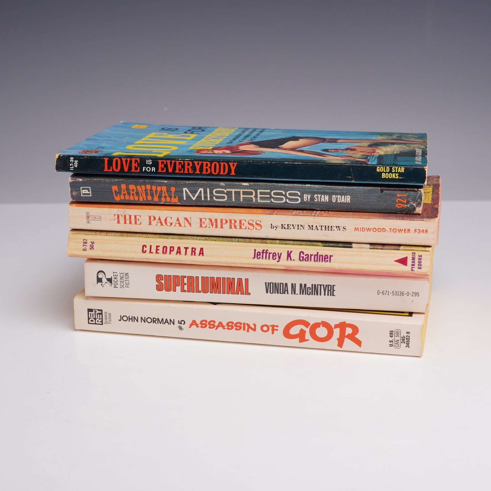6pc Erotica Sleaze and Pulp Fiction Paperbacks. Various Publishers, c. 1959-1984.: This 6-piece collection of vintage mass-market paperbacks showcases a diverse range of mid-to-late 20th-century pulp fiction, spanning erotica, sleaze, historical fiction, and science fiction. The ass