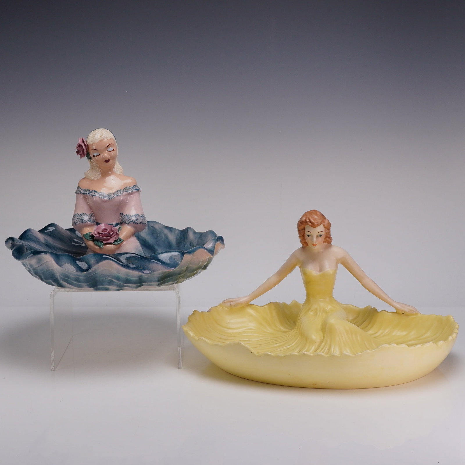 2pc Mid-Century California Pottery Porcelain Figures with Dress Bowls: This set of t0w porcelain figures with dress bowls represents the mid-century California pottery movement. One figure depicts an auburn-haired woman in a yellow strapless gown with arms outstretched, 