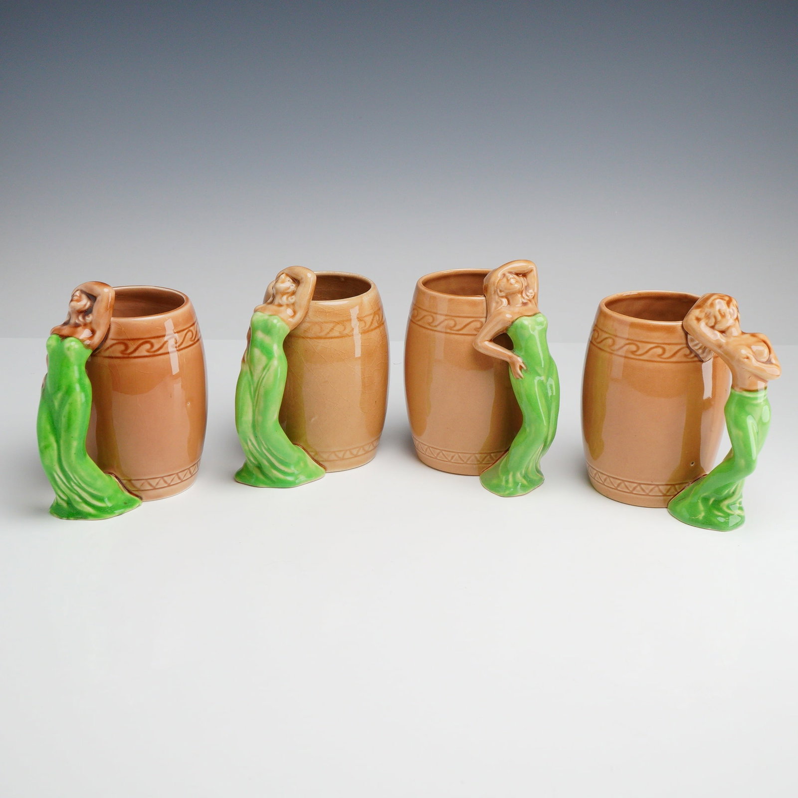 Set of 4 Mid-Century Japanese Ceramic Risque Novelty Mugs in the Style of Dorothy Kindell: A set of 4 ceramic risque mugs produced in Japan during the mid-20th century, designed in the style of American ceramicist Dorothy Kindell. Each mug features a barrel-shaped earthenware body with a fi