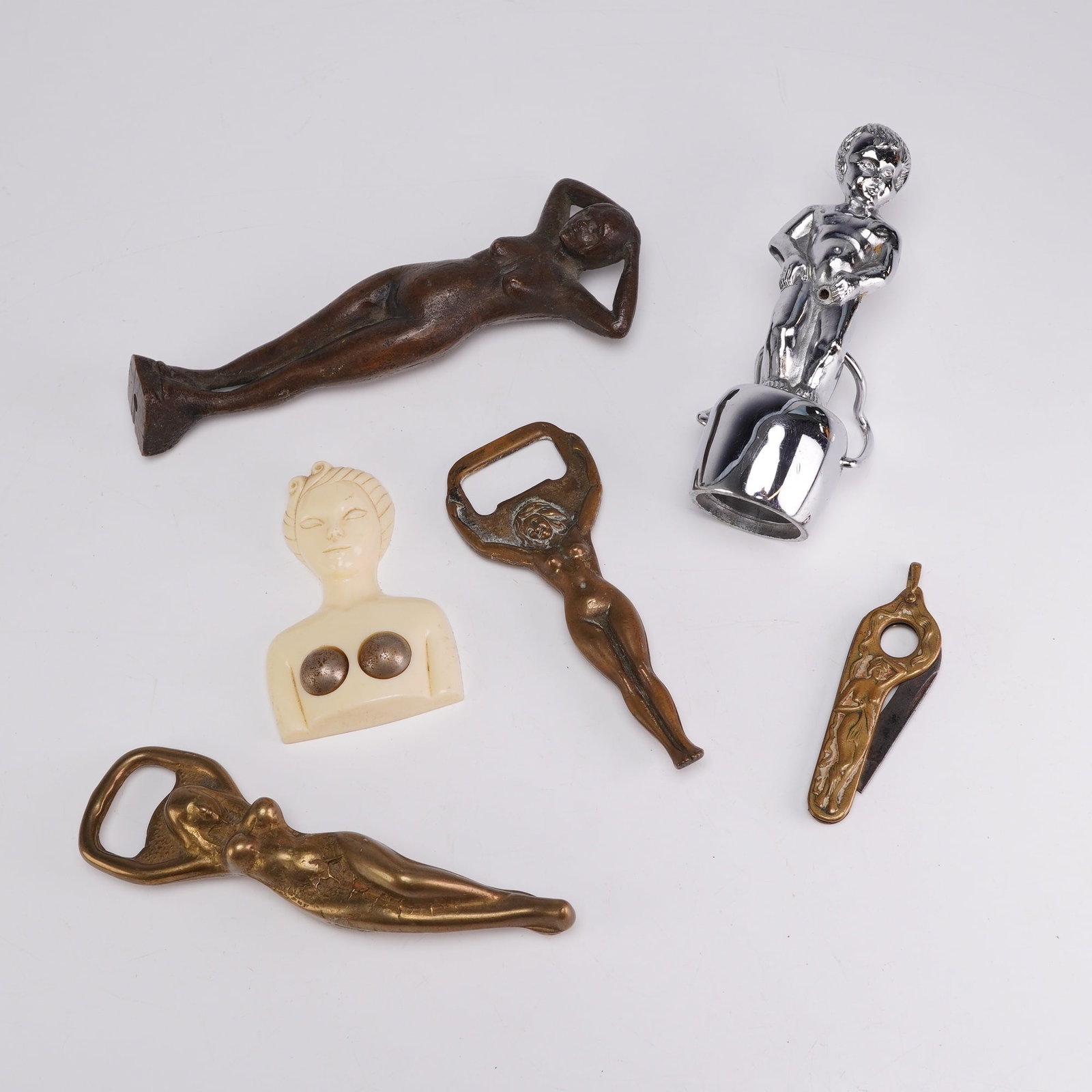 6pc Mid-Century Risque Novelties and Figural Bottle Openers: This assortment consists of six mid-century barware novelties and sexy items featuring nude figures. Included is an S.S. Adams Pluck-Em Puzzle made of white plastic or celluloid in the form of a
