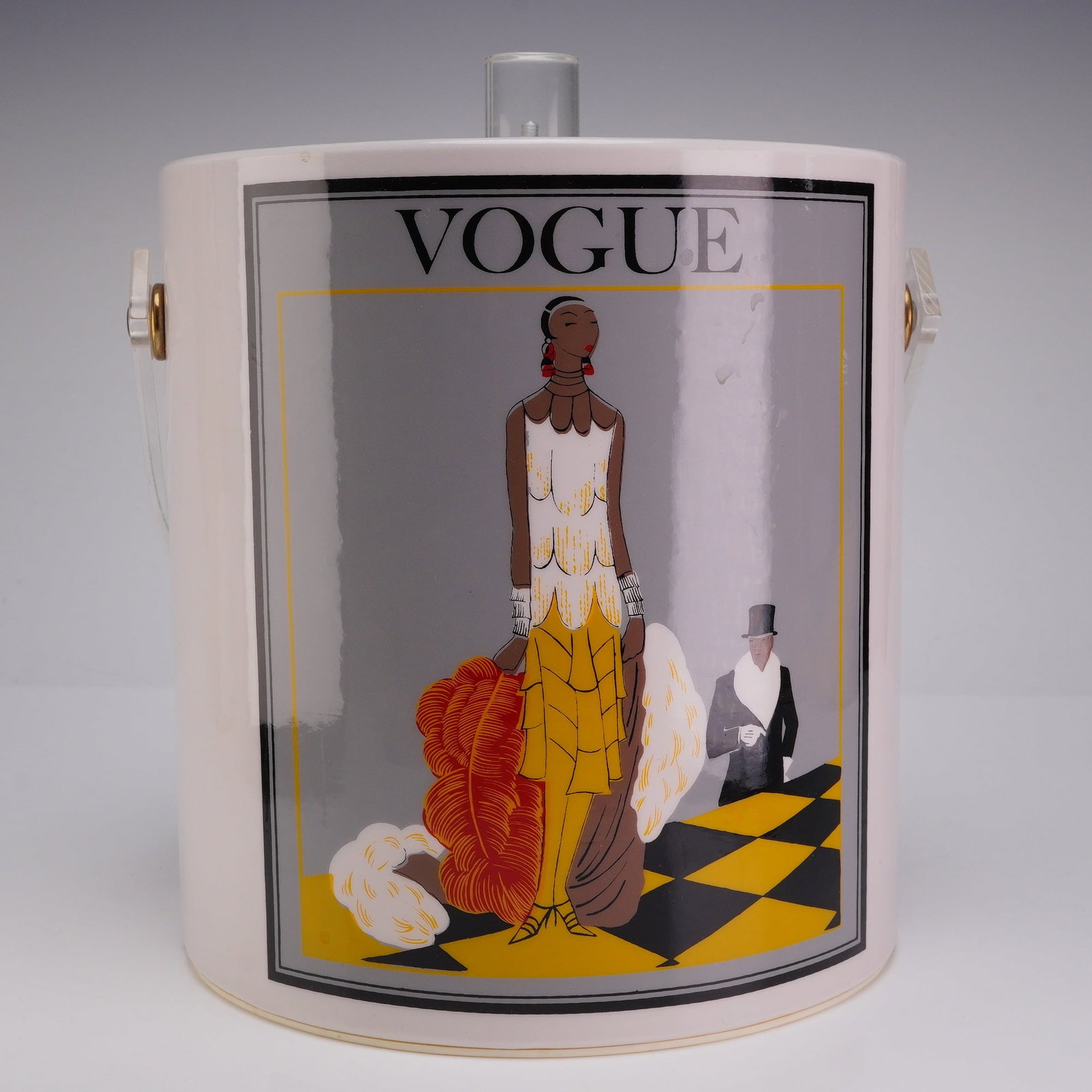 Cera Vogue Ice Bucket with Two Pairs of Ice Tongs: The ice bucket is attributed to Cera, circa 1960s, and features a vinyl-wrapped cylindrical body with a clear acrylic Lucite swivel handle and lid knob. The exterior displays wrap-around graphics
