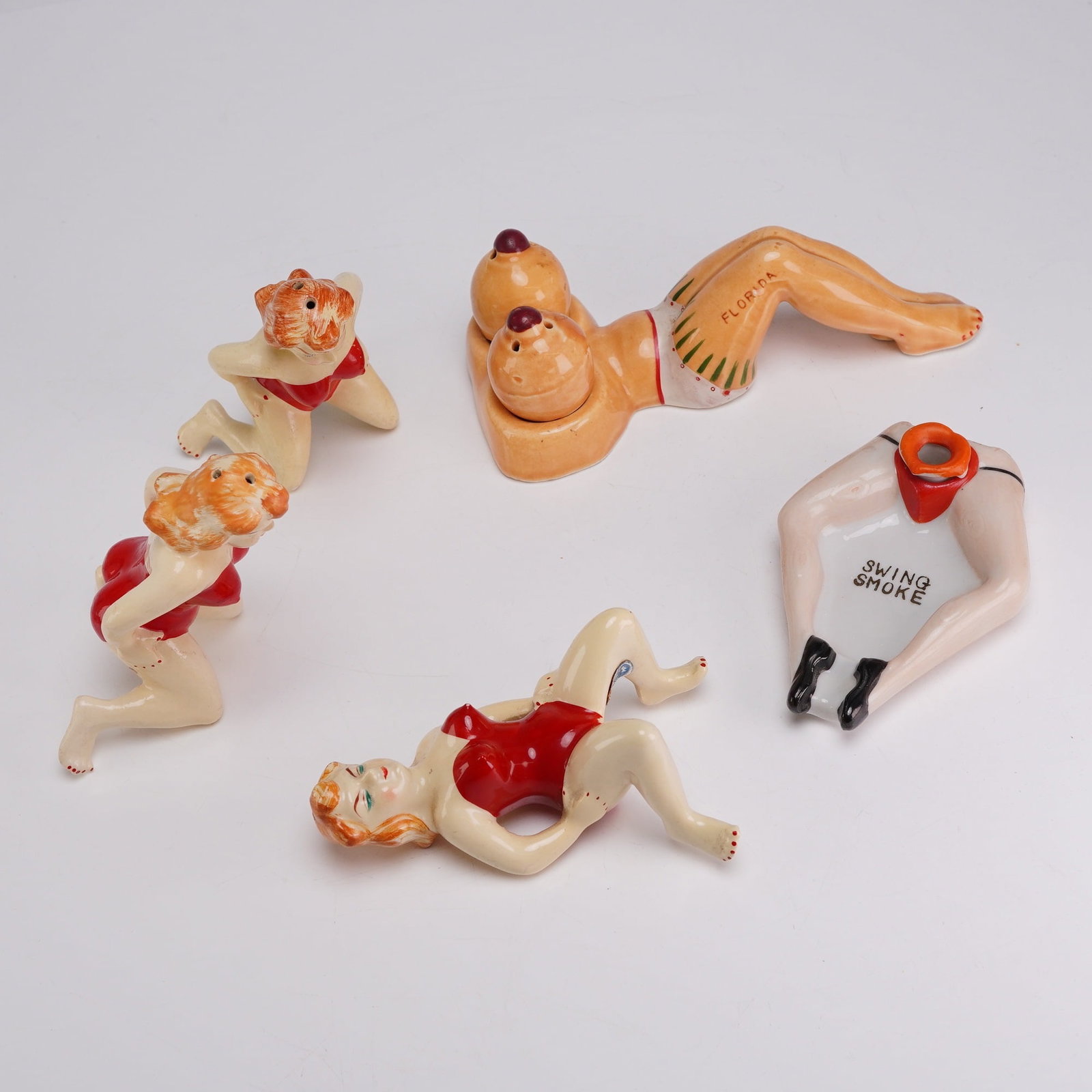 5pc Mid-Century Japanese & American Risque Souvenir Ceramic Novelties: This collection of five mid-20th-century novelty ceramics features various risque designs typical of the American souvenir market from the 1950s and 1960s. The group includes a three-piece salt and pe