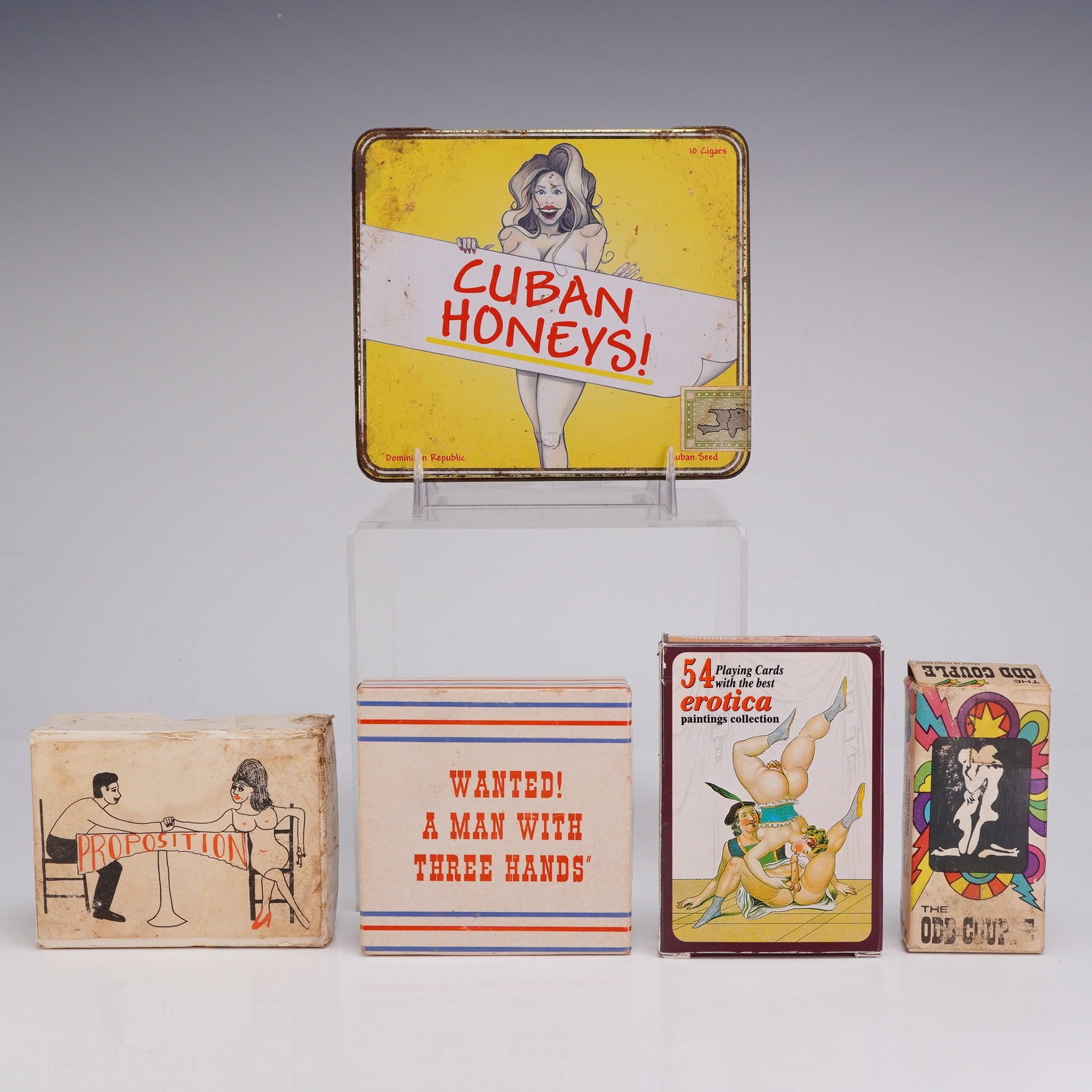 5pc Collection of Vintage Erotic Novelties and Tobacciana: This collection consists of five vintage items featuring erotic and pin-up themes. The group includes a lithographed metal cigar tin for Cuban Honeys, which features a blonde pin-up illustration and
