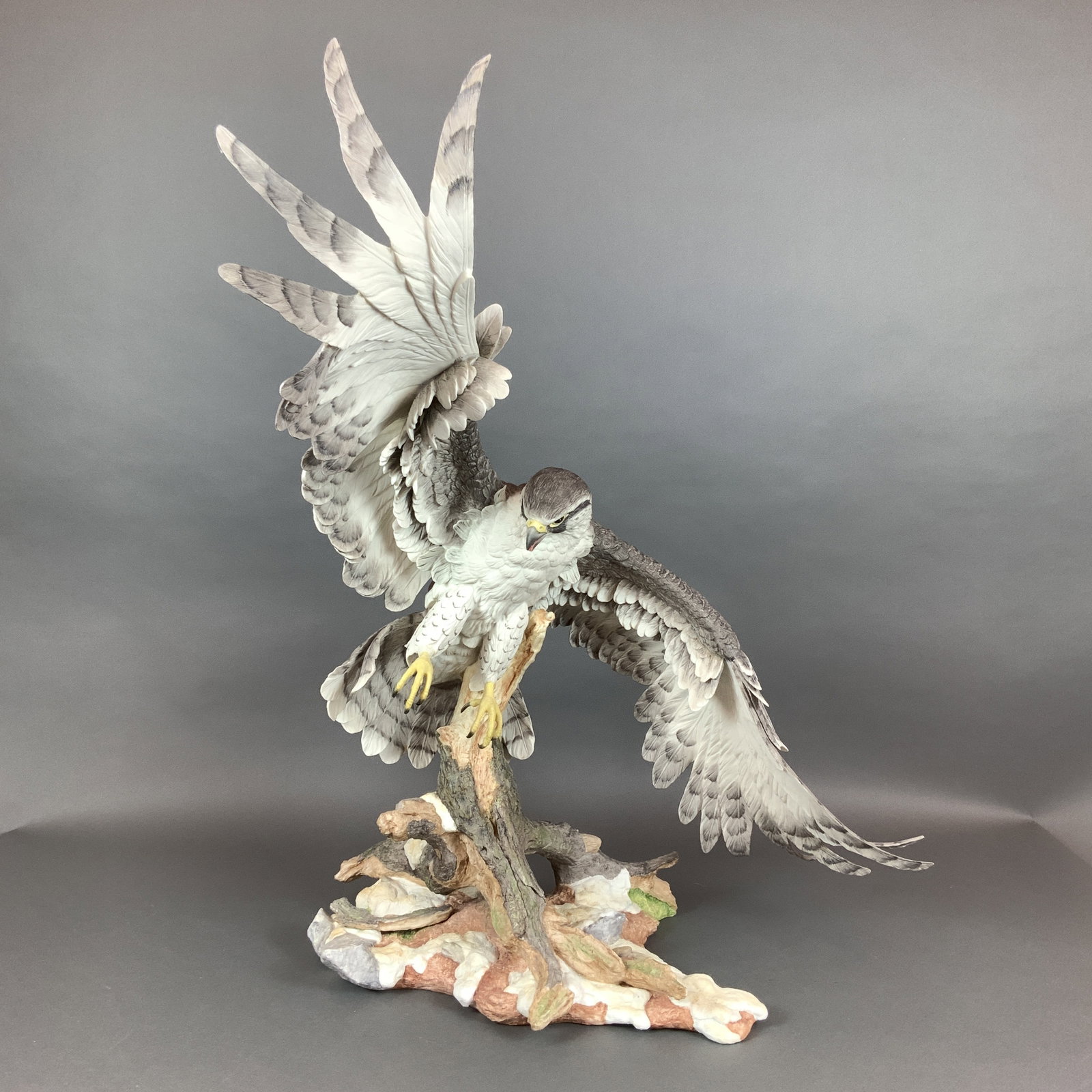 Boehm Limited Issue Porcelain Gyr Falcon Sculpture: This hand-painted porcelain sculpture by the Boehm studio depicts a Gyr Falcon (Falco rusticolus rusticolus) in flight. The bird is captured in a dynamic pose with wings spread and talons extended,