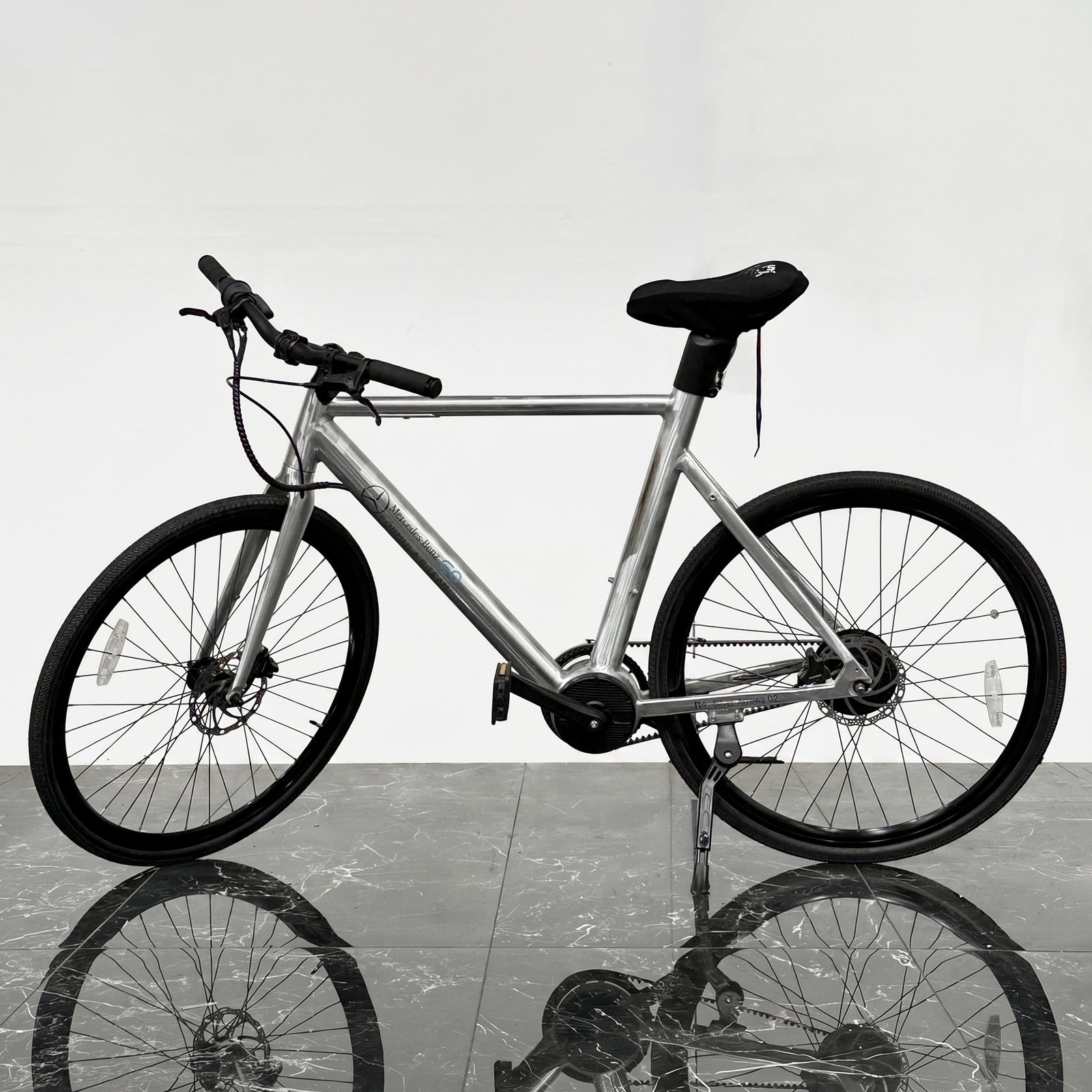 Mercedes-Benz EQ Formula E Team n+ Silver Arrows 02 Electric Bicycle with Charger and Blackburn: This Mercedes-Benz EQ Formula E Team n+ Silver Arrows 02 electric bicycle features a brushed silver-toned aluminum frame with integrated internal cabling. The down tube bears a logo consisting of a