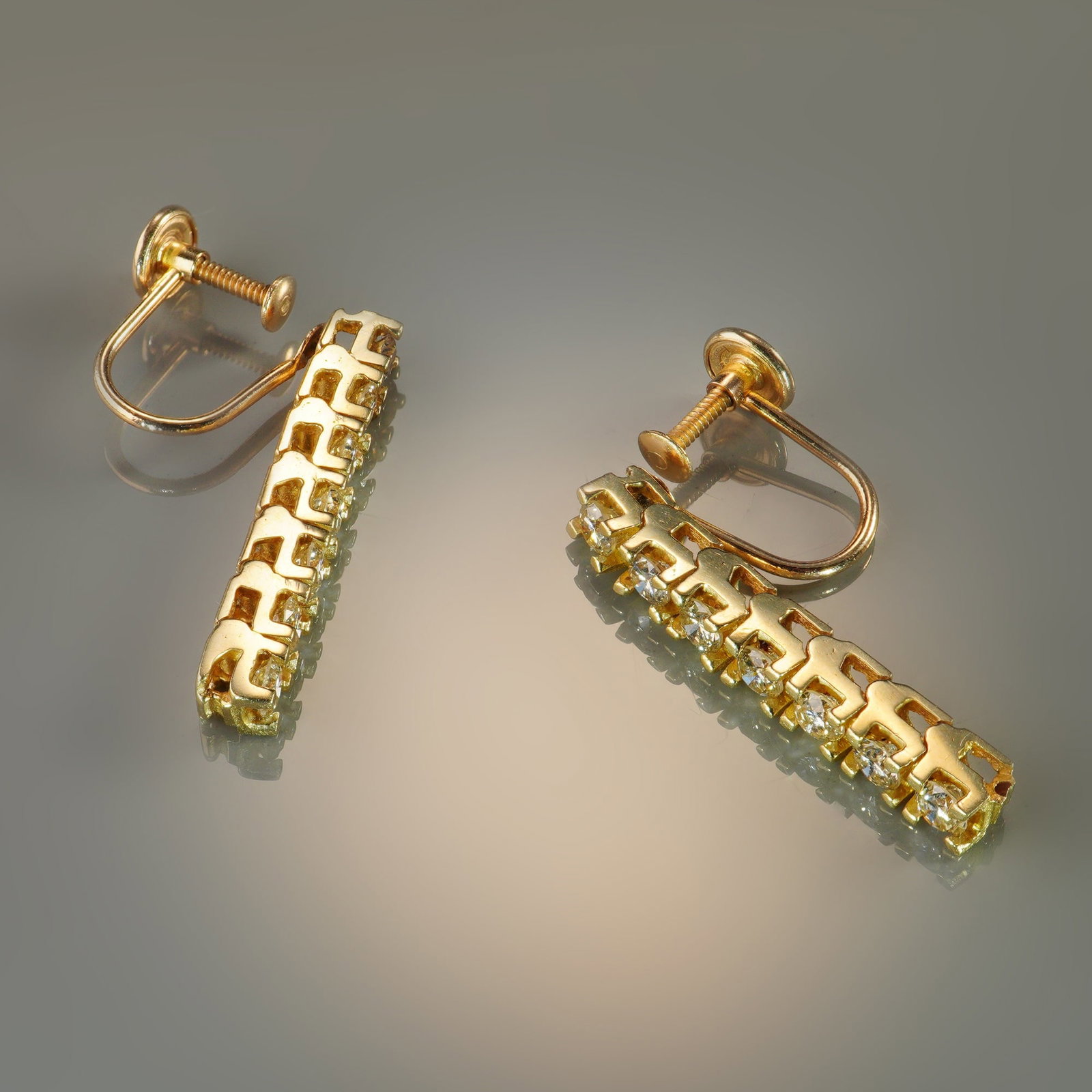 14K Gold 1.00ctw Diamond Screw-Back Drop Earrings: A refined pair of 14K gold bar drop earrings, each set with seven sparkling round diamonds for a total of 14 stones weighing approximately 1.00 carat. The clean vertical design emphasizes the