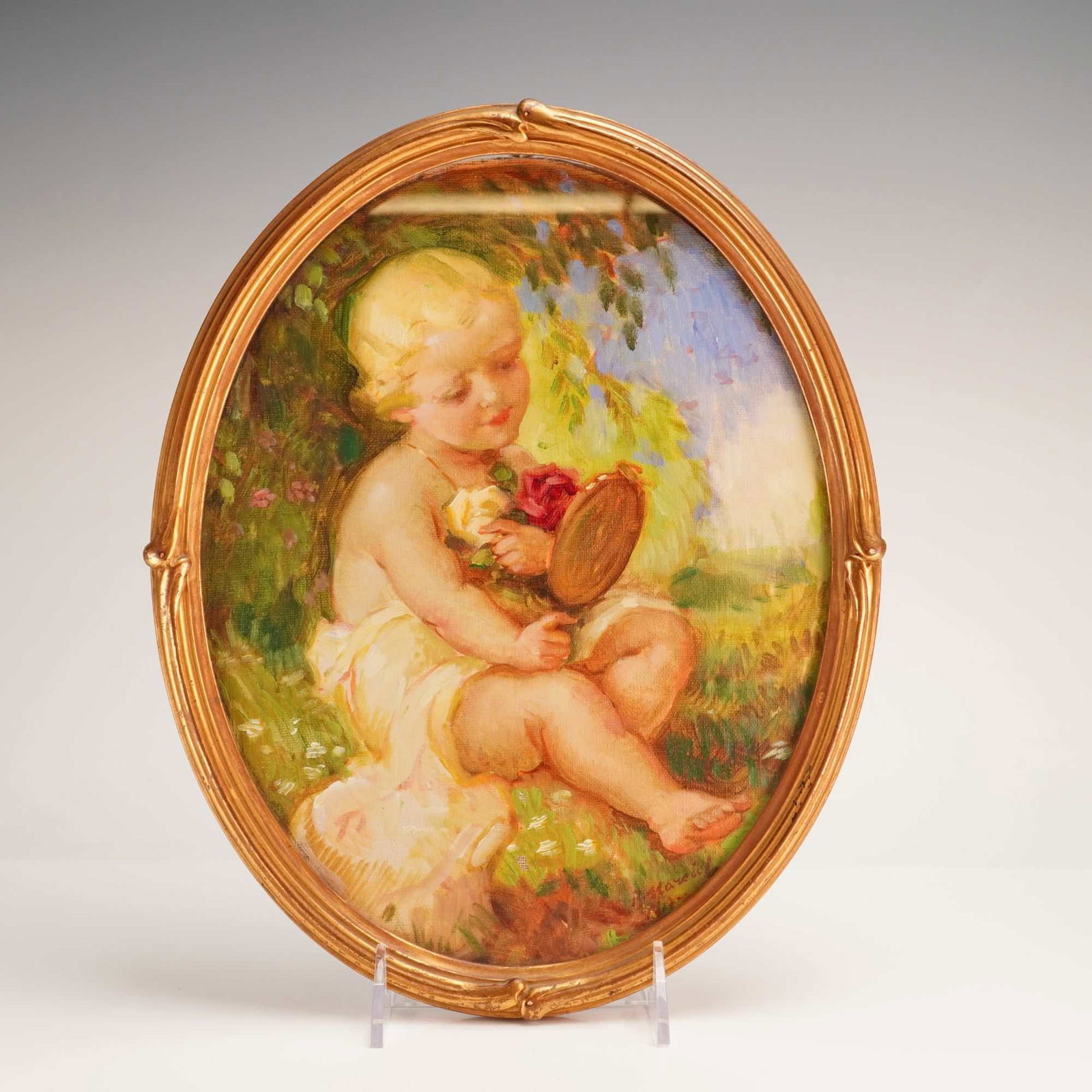 Attributed to Ludek Marold, Child with Roses, Oil on Canvas, ca. 1910: This original oil on canvas painting, presented in a decorative oval frame, depicts a sentimental scene of a fair-haired young child seated in a sun-drenched garden setting. The child, partially