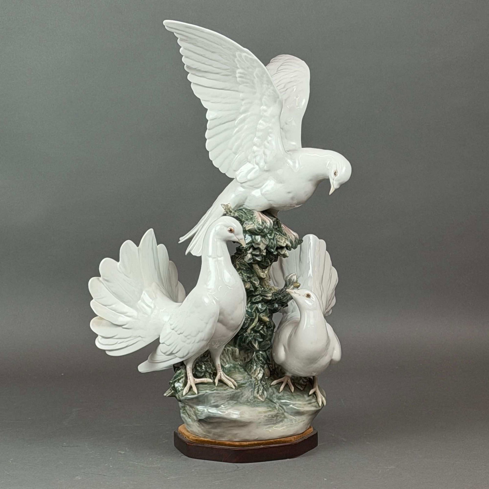 Lladro Porcelain Group of Doves Sculpture, Model 1335: This large-scale Lladro porcelain sculpture, item #01001335, features a group of three white doves (pigeons) depicted in a naturalistic setting. The composition includes one bird at the top with wings