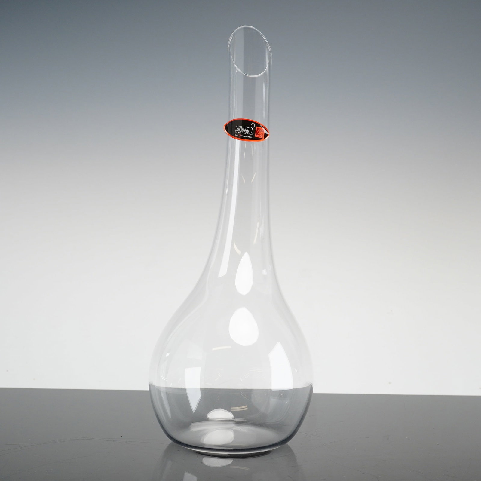 Riedel Cornetto Hand-Made Crystal Wine Decanter with Original Box: A contemporary hand-blown crystal wine decanter in the Syrah pattern produced by Riedel. The piece is crafted from clear crystal glass and features a large, bulbous teardrop-shaped reservoir that tape