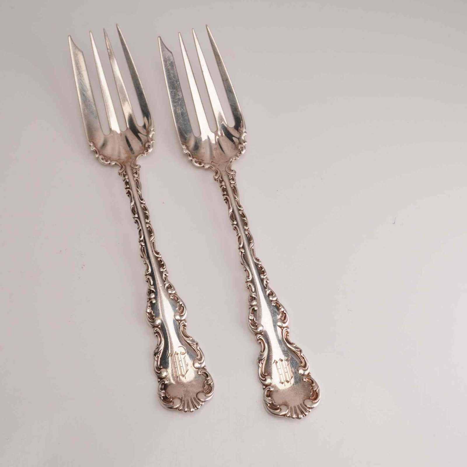 2pc Whiting Manufacturing Company Sterling Silver Fish Forks, Louis XV: A pair of sterling silver individual fish forks in the Louis XV pattern, manufactured by the Whiting Manufacturing Company. Each fork is designed with a wide four-tine head and a characteristic notche