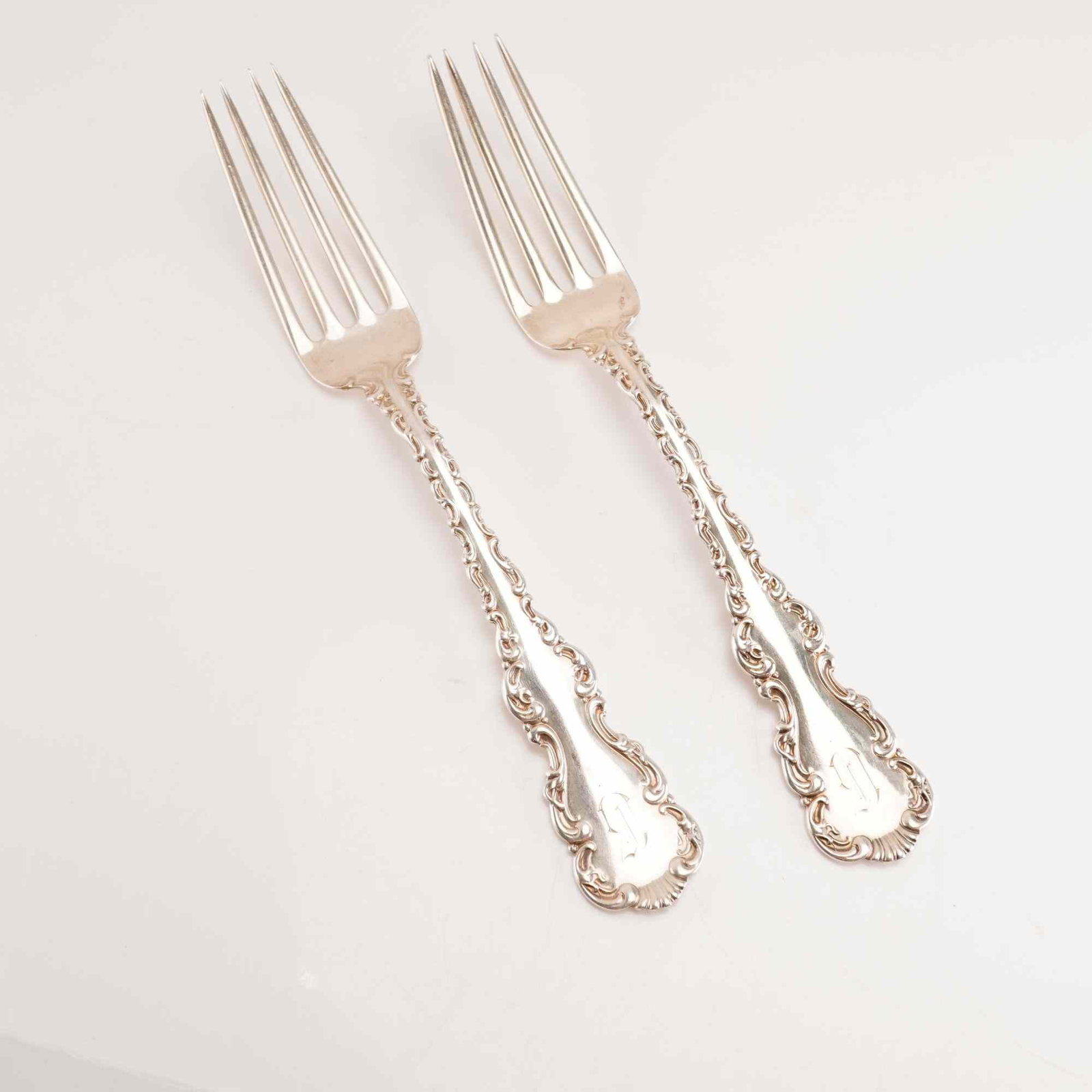 2pc Whiting Manufacturing Company Sterling Silver Forks, Louis XV: A pair of sterling silver forks produced by the Whiting Manufacturing Company in the Louis XV pattern, which was first introduced in 1891. The handles feature an ornate Rococo Revival design with scro