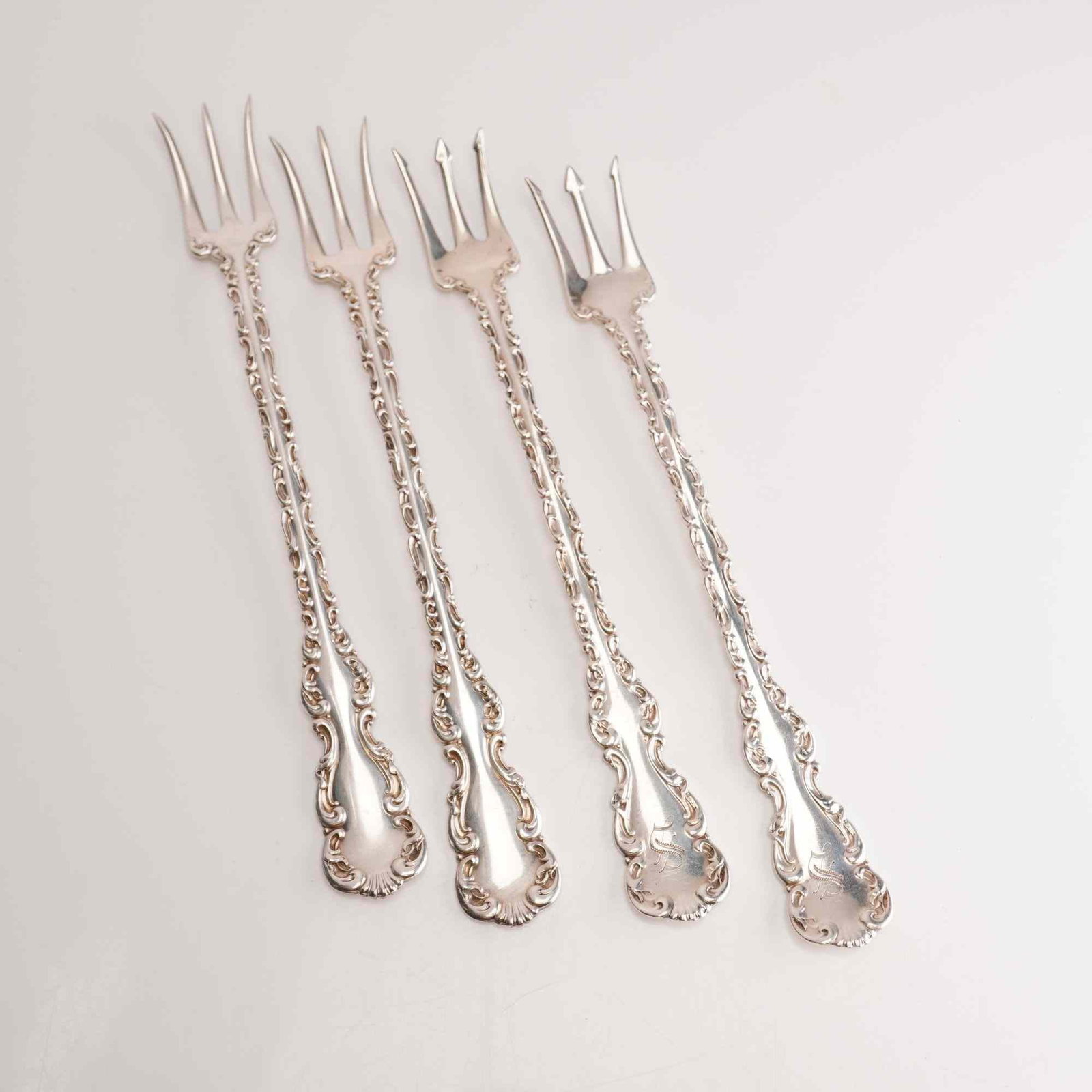 4pc Whiting Manufacturing Co. Sterling Silver Cocktail Forks, Louis XV: A set of four sterling silver cocktail forks in the Louis XV pattern by the Whiting Manufacturing Company. The forks feature long, slender handles decorated with ornate Rococo Revival style scrolls an