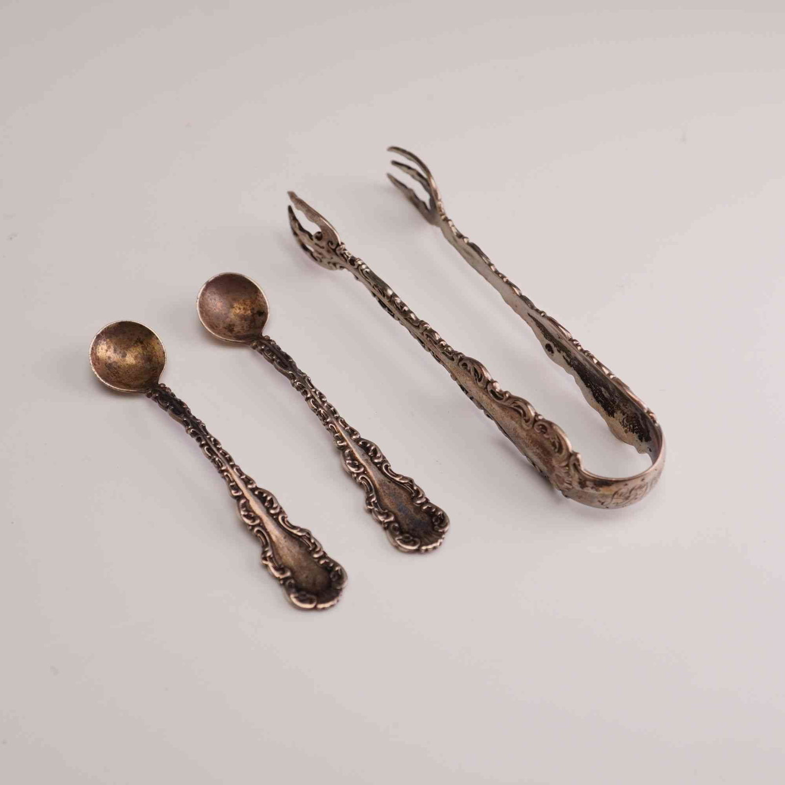 3pc Whiting Manufacturing Company Sterling Silver Miniature Spoons and Tongs, Louis XV: A trio of American sterling silver items produced by the Whiting Manufacturing Company, featuring the Louis XV pattern introduced in 1891. The collection consists of one pair of sugar tongs and two sm