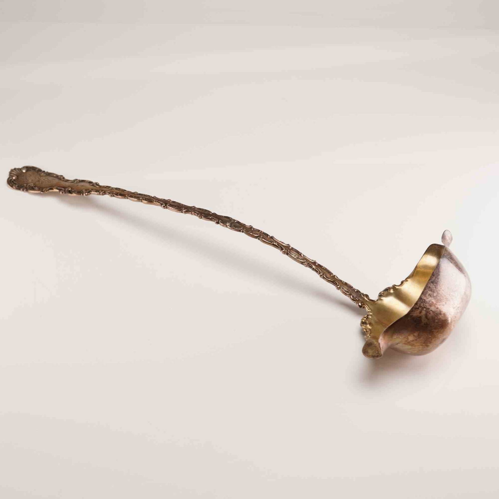 Whiting Manufacturing Co. Sterling Silver Double Lipped Sauce Ladle: A sterling silver sauce ladle produced by the Whiting Manufacturing Company and retailed by the Boston firm Shreve, Crump & Low Company. The ladle is designed featuring an ornate Rococo-style handle d
